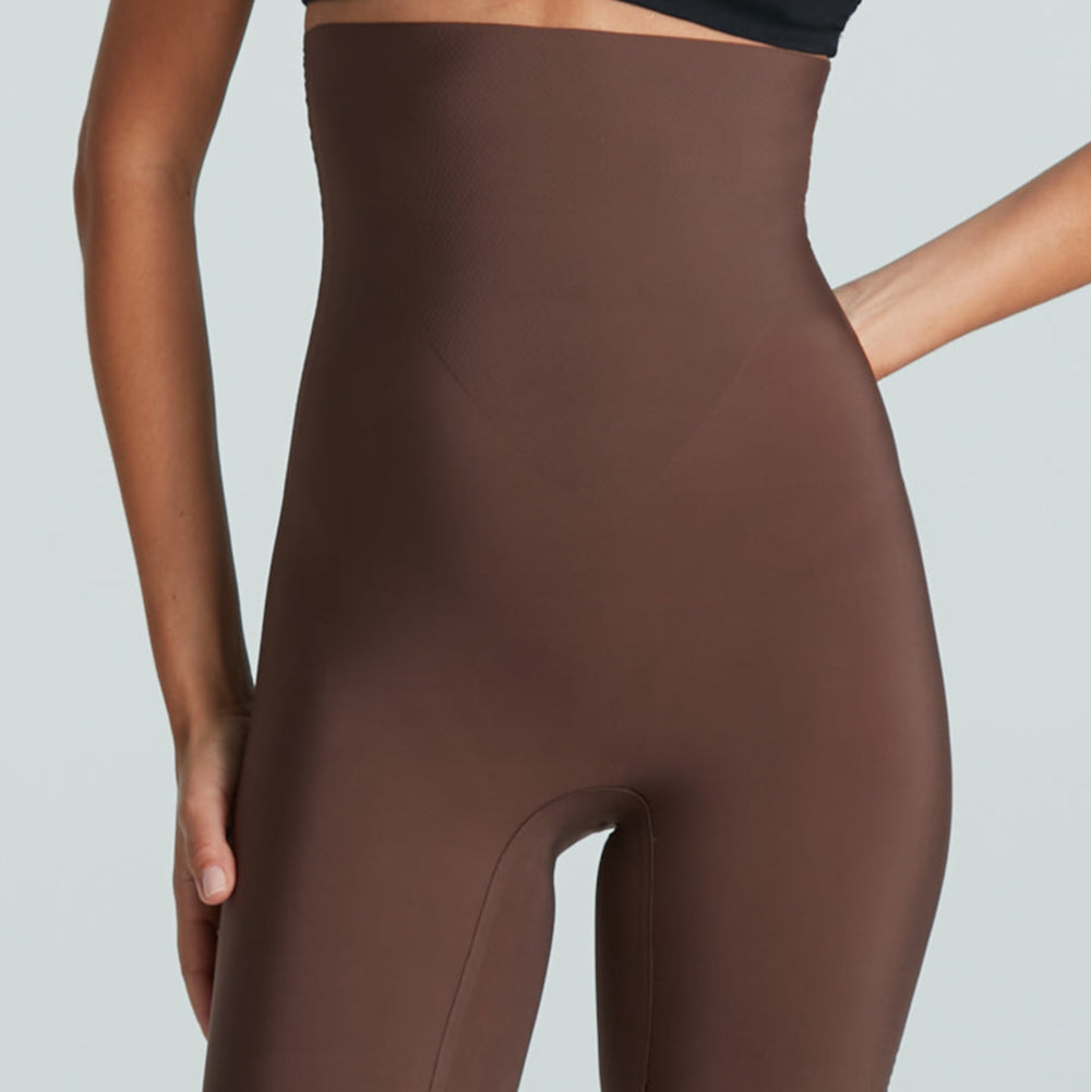 Brown shapewear shorts worn by a model on a light gray background