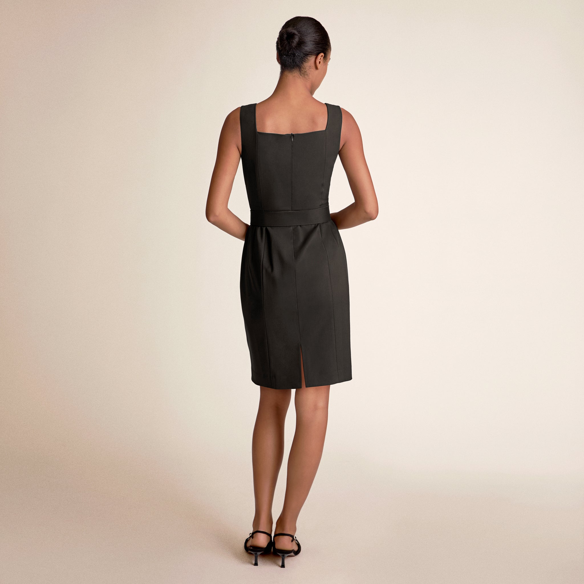 Woman wearing a black dress on a beige background