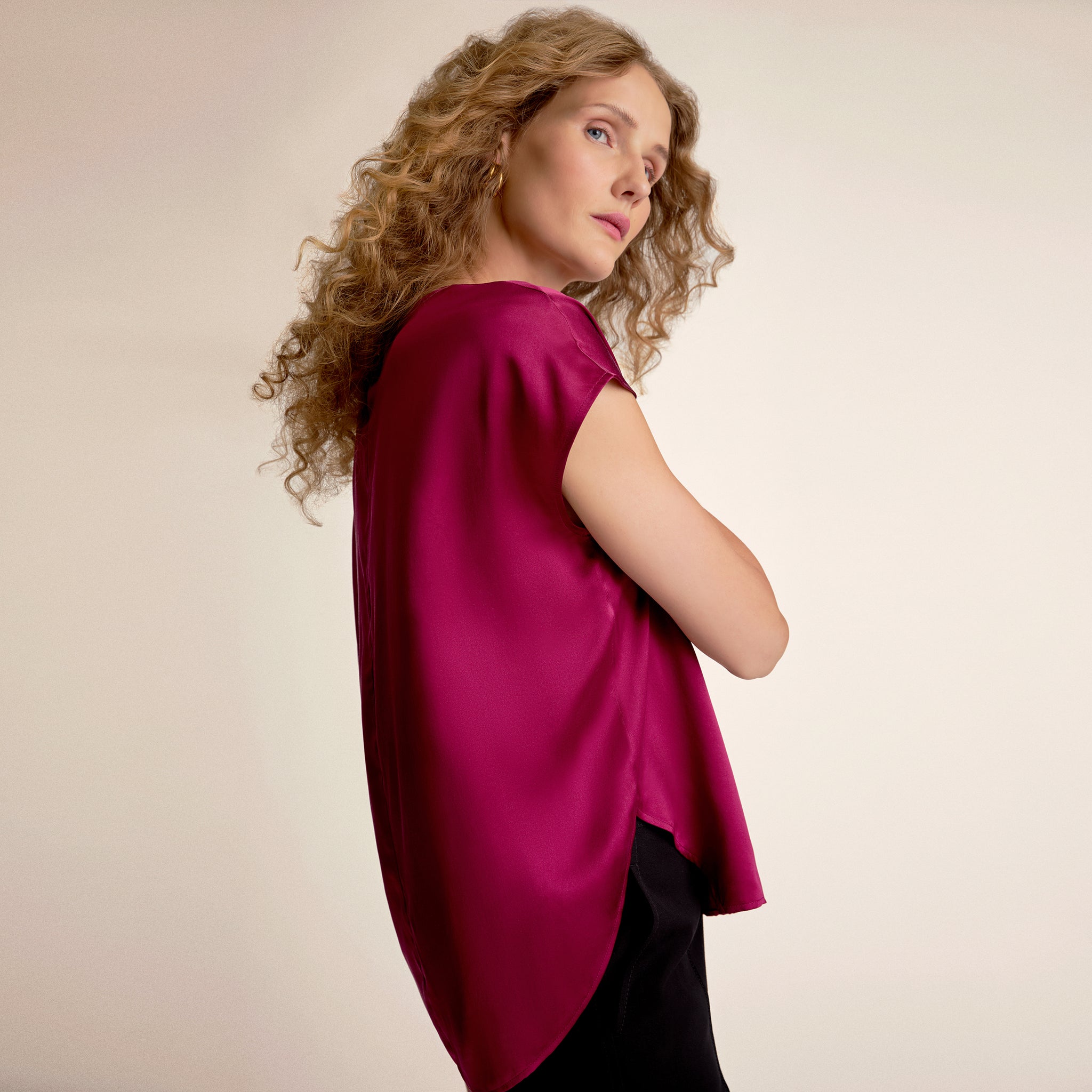 Woman wearing a magenta top against a beige background