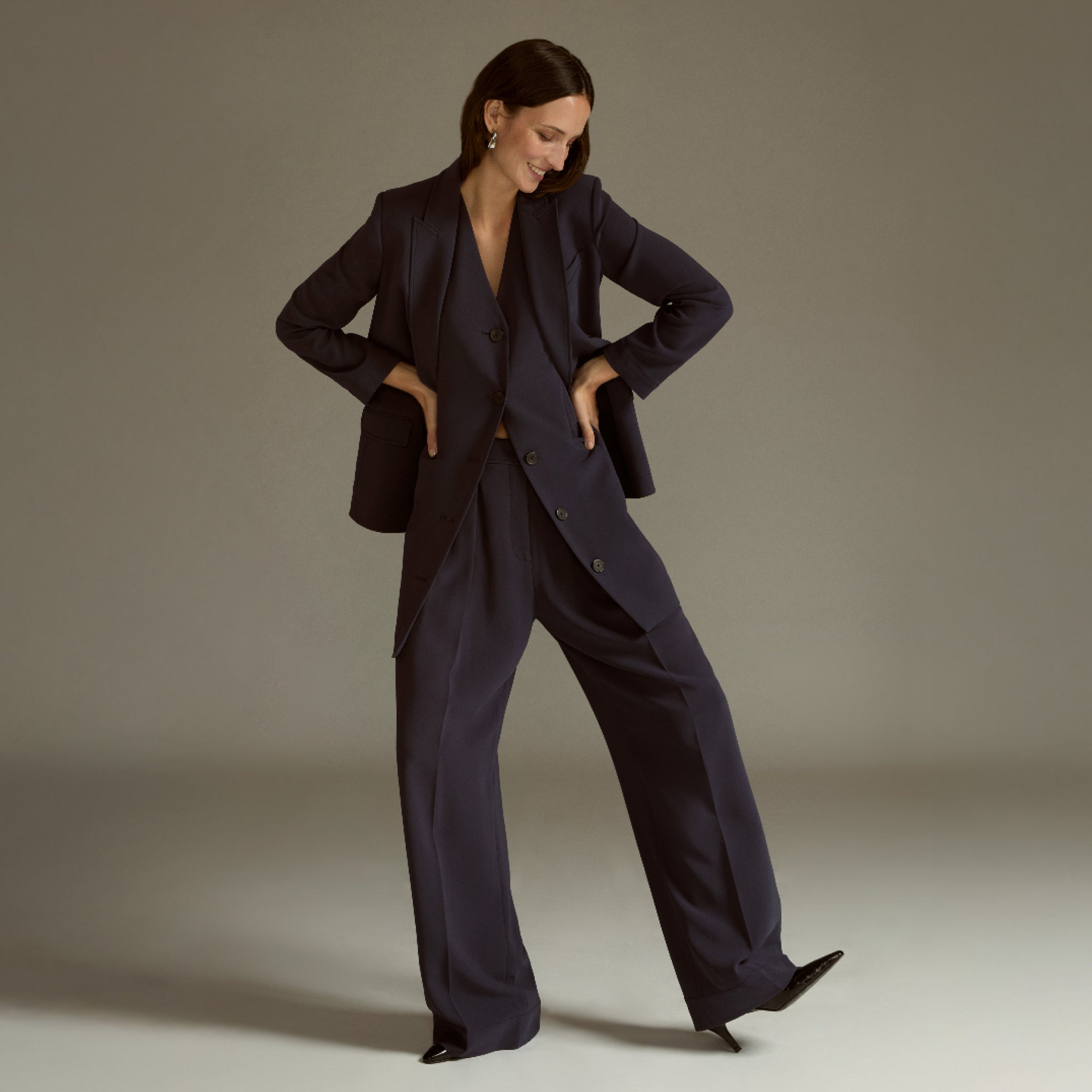 Woman wearing a dark blue suit against a neutral background