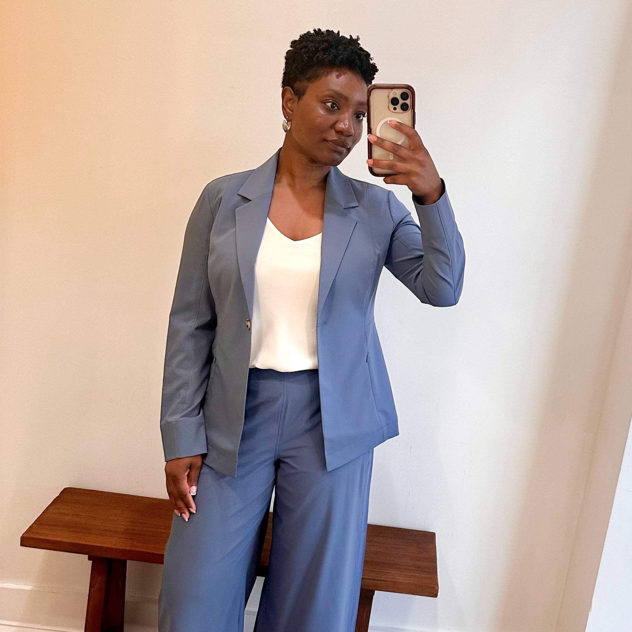 Person wearing a blue suit taking a mirror selfie.