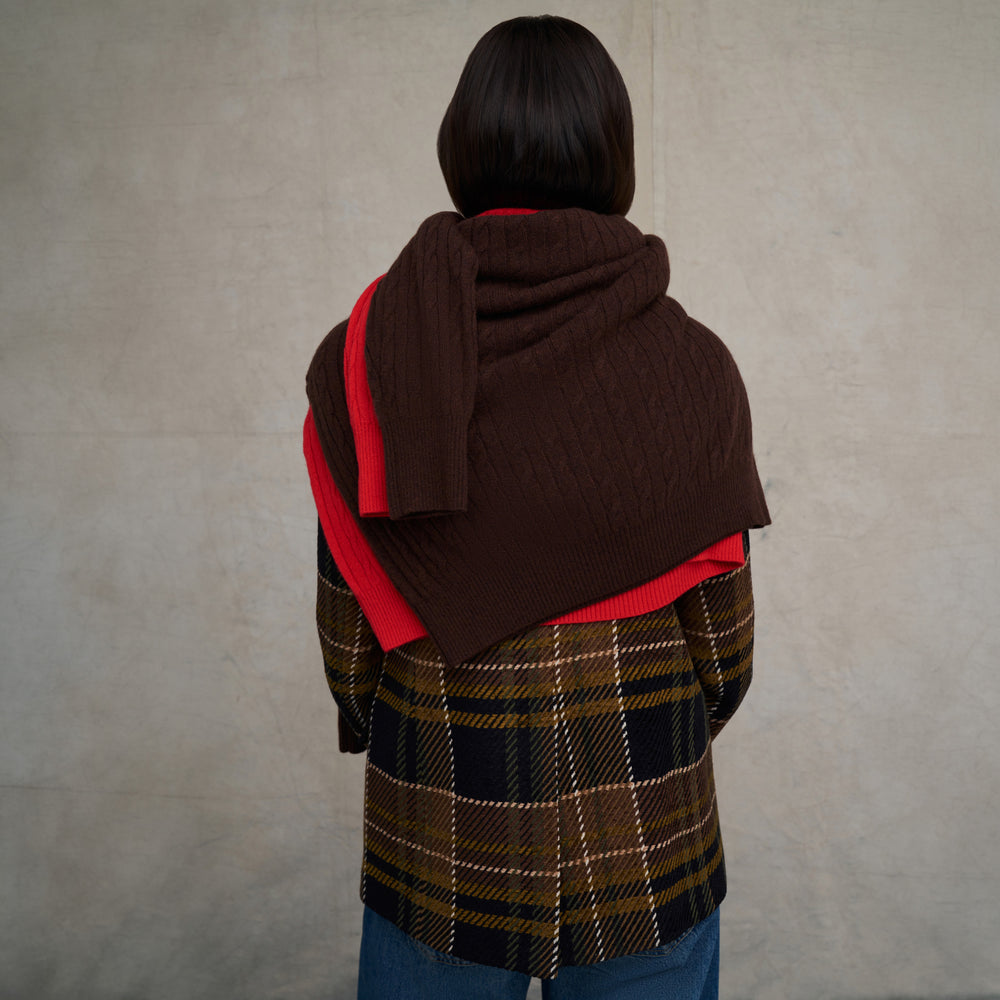 Woman wearing the O'Hara Blazer in Heritage Plaid with wide leg jeans on a beige background with blue floor