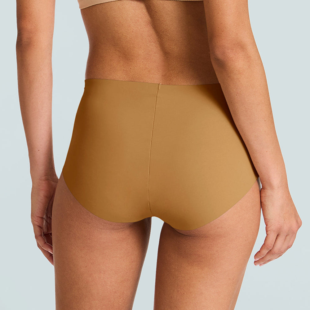 Person wearing a beige sports bra and high-waisted mustard yellow underwear on a light blue background