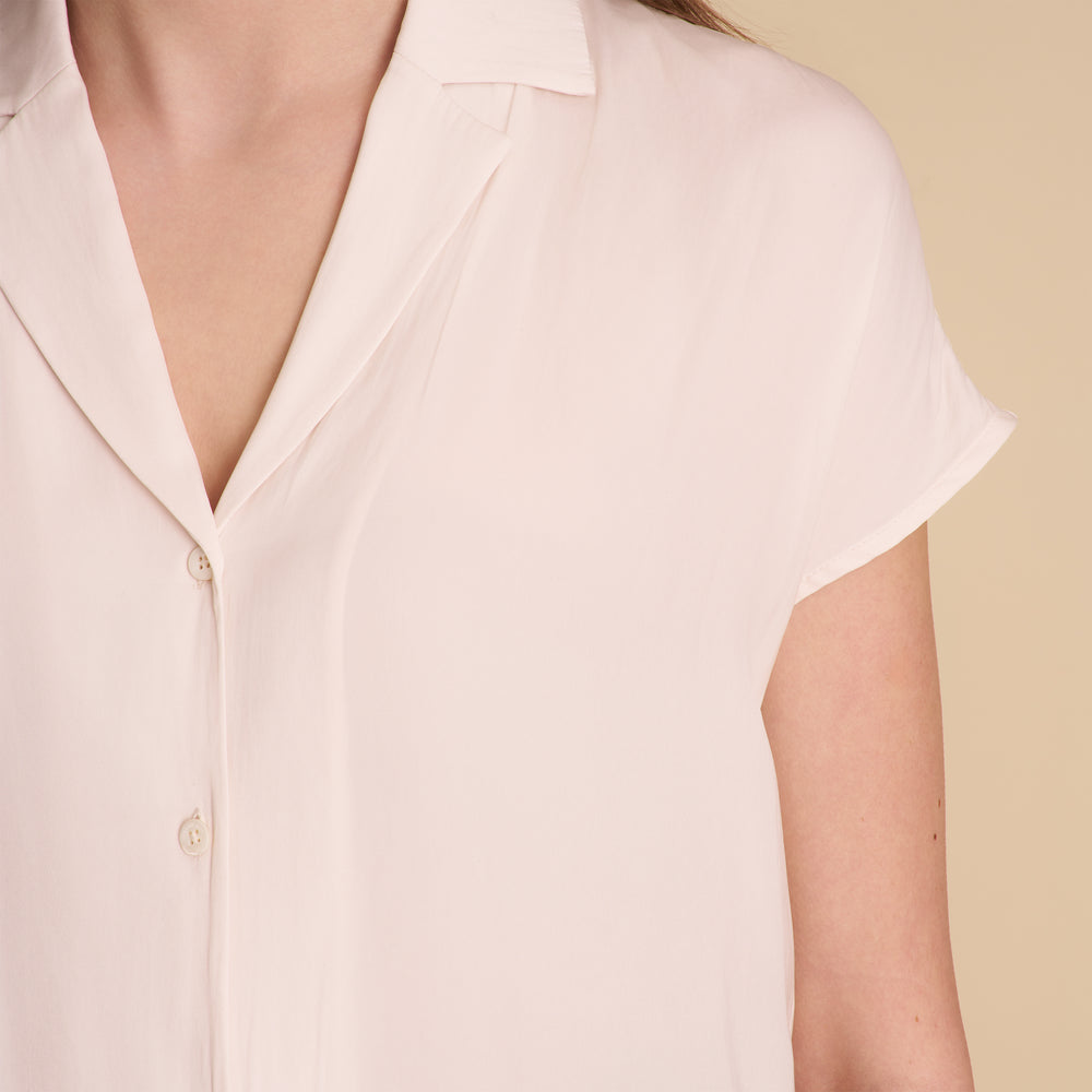 woman in white blouse on beige background.