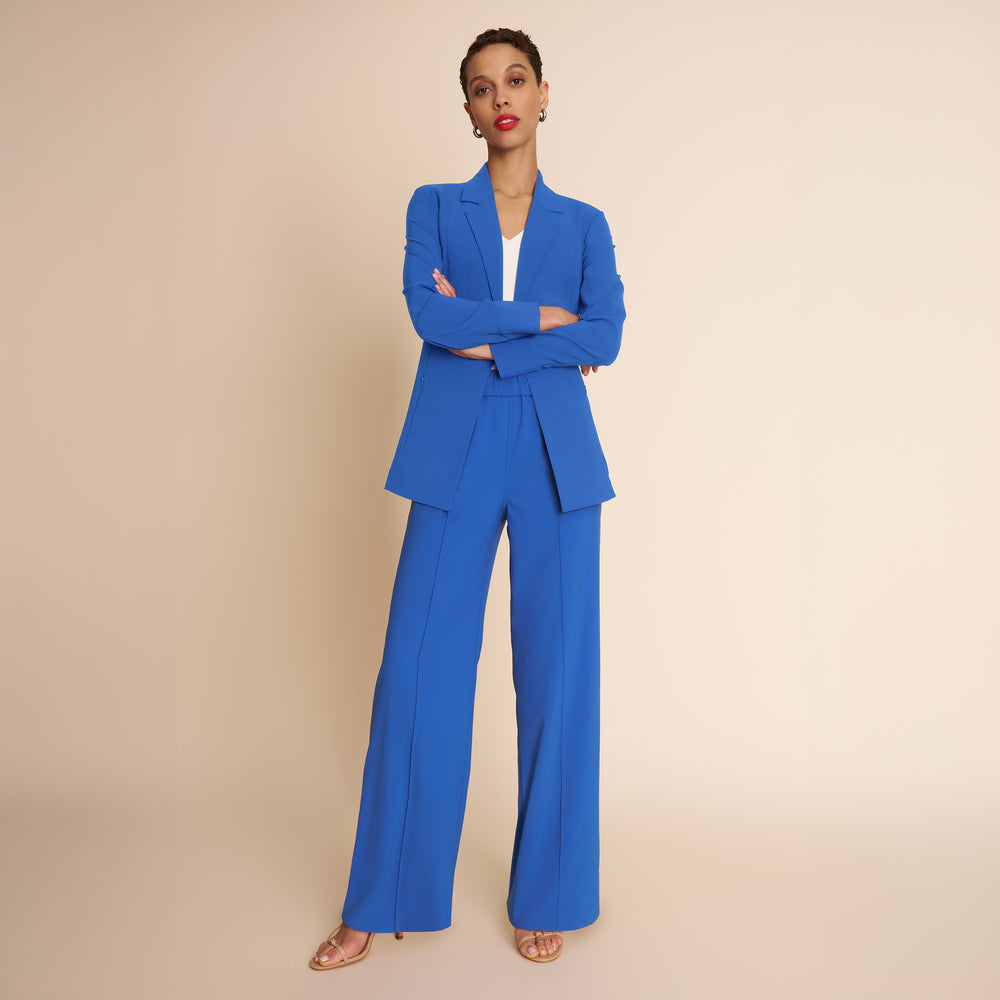 Woman wearing a blue suit against a beige background