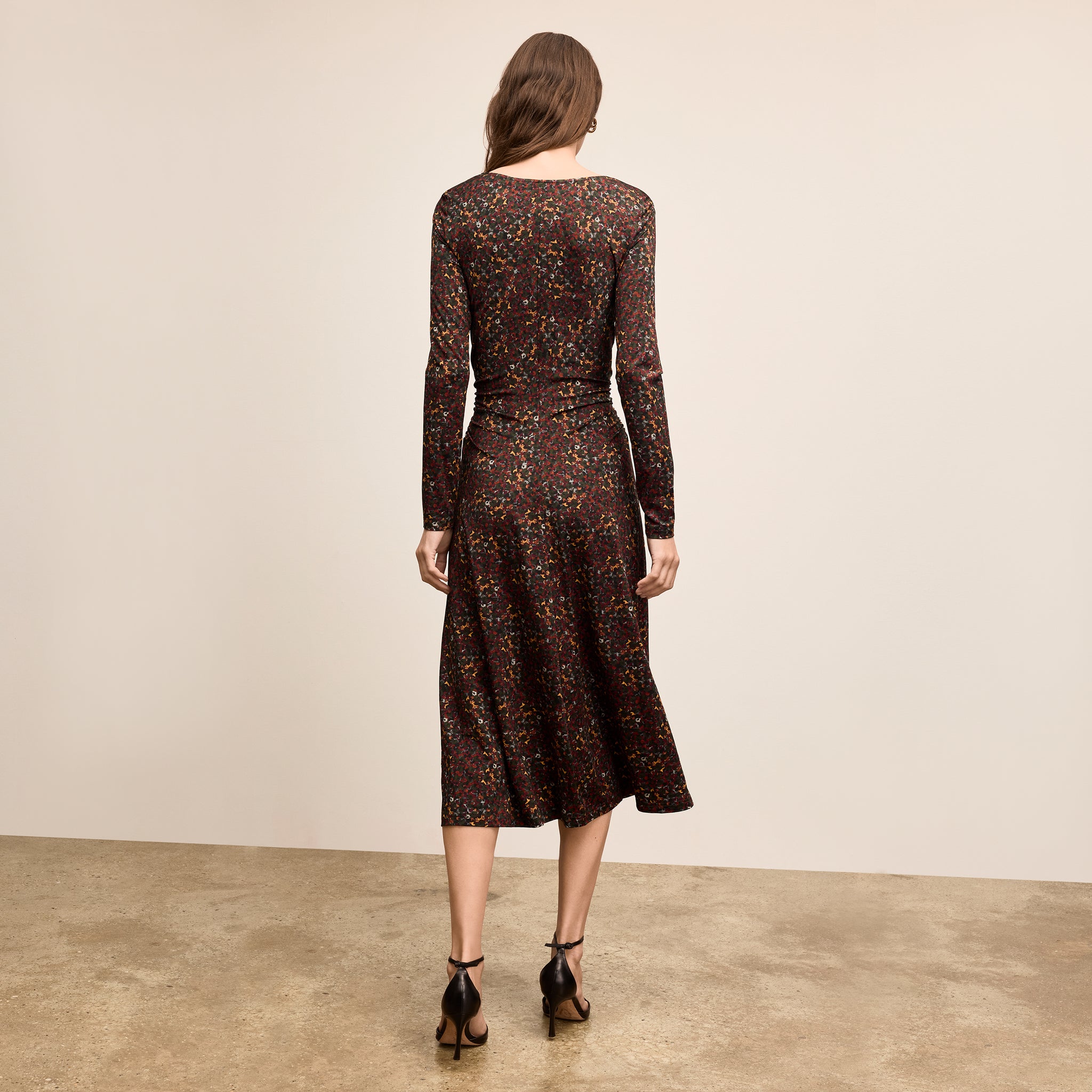 Woman wearing a patterned dress against a plain background