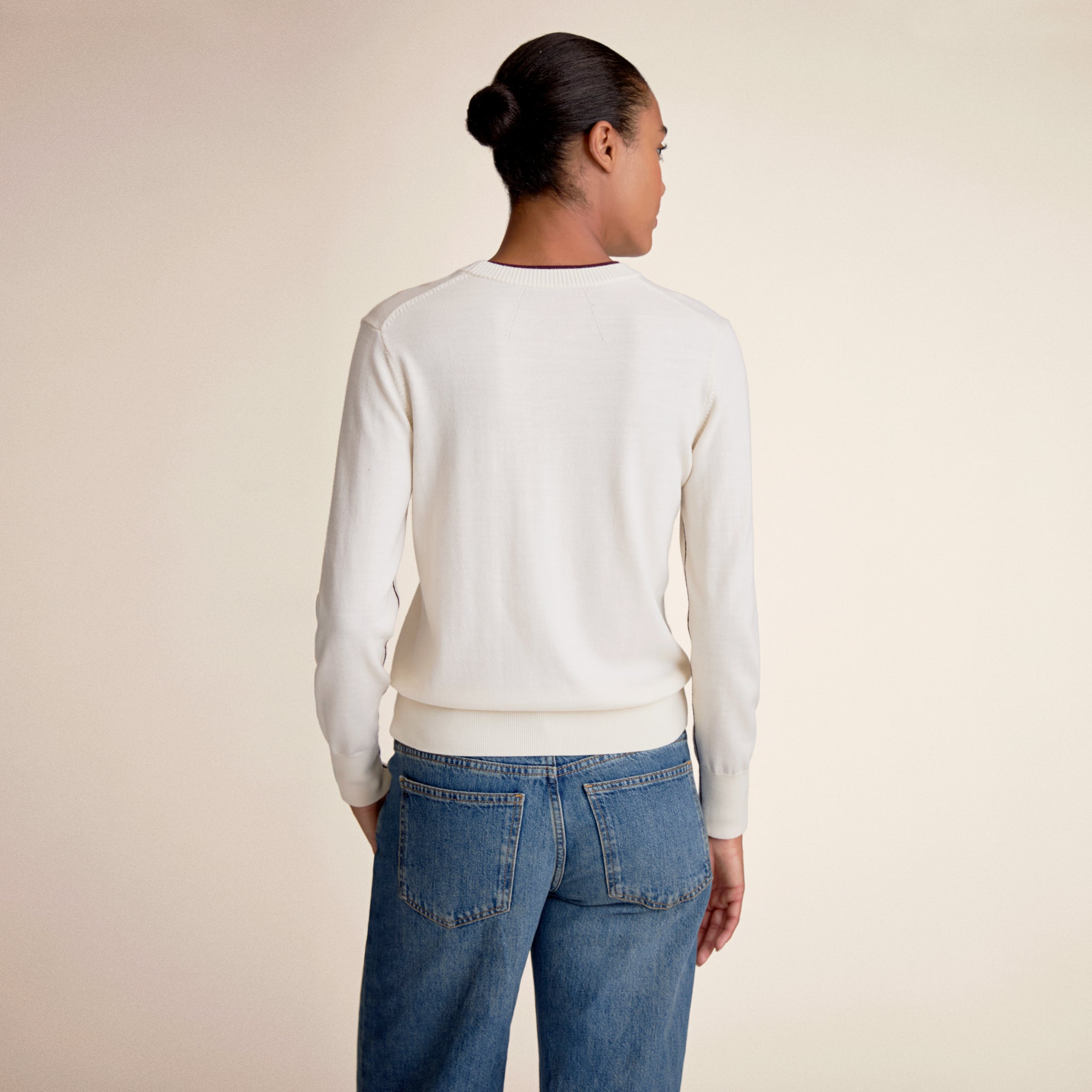 Person wearing a white long sleeve sweater