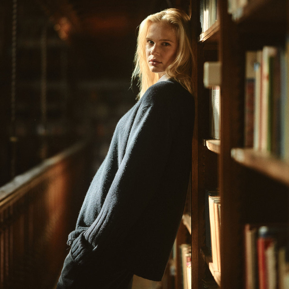 Woman standing in a library with bookshelves around her