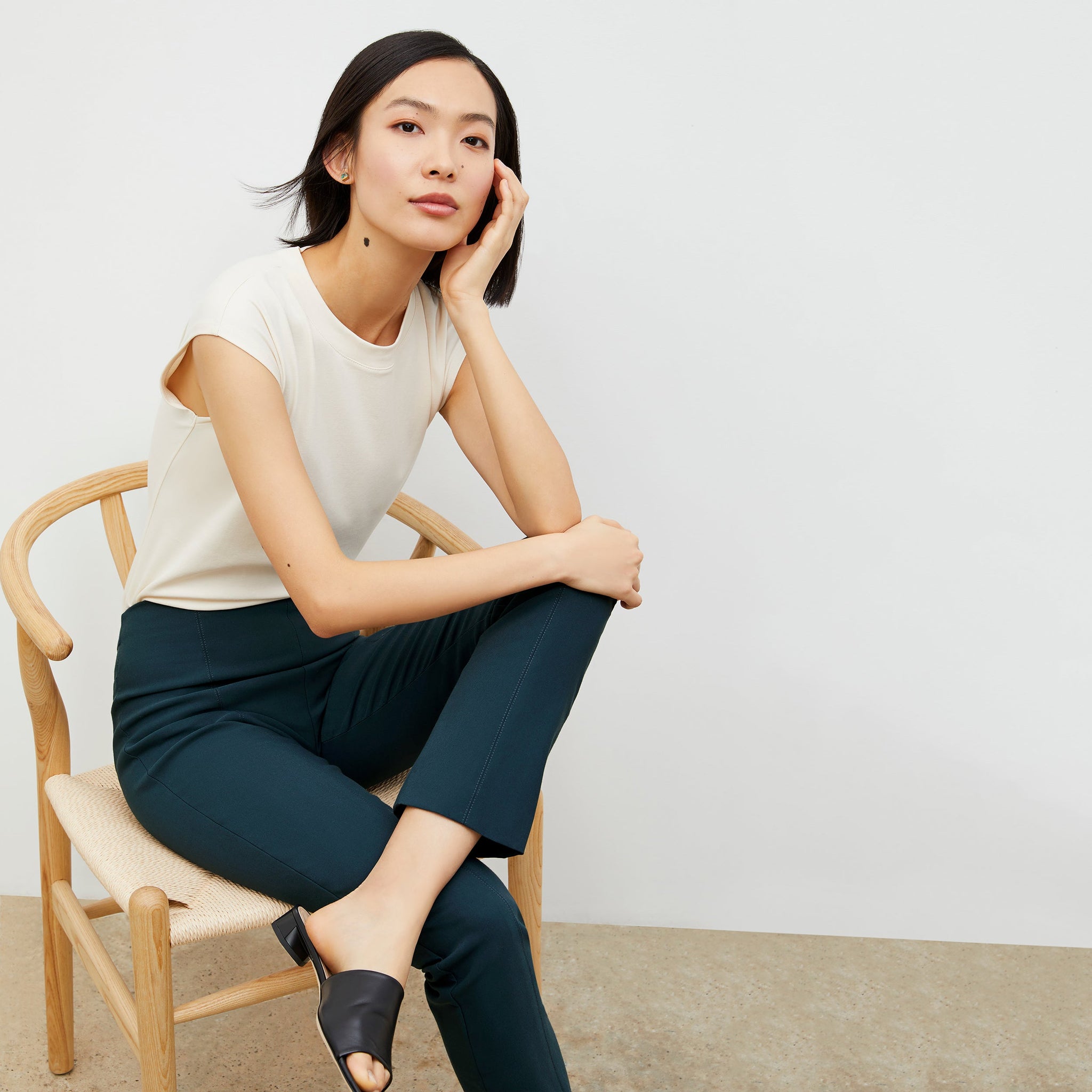 Front image of a woman standing wearing the alina top in compact cotton in ivory