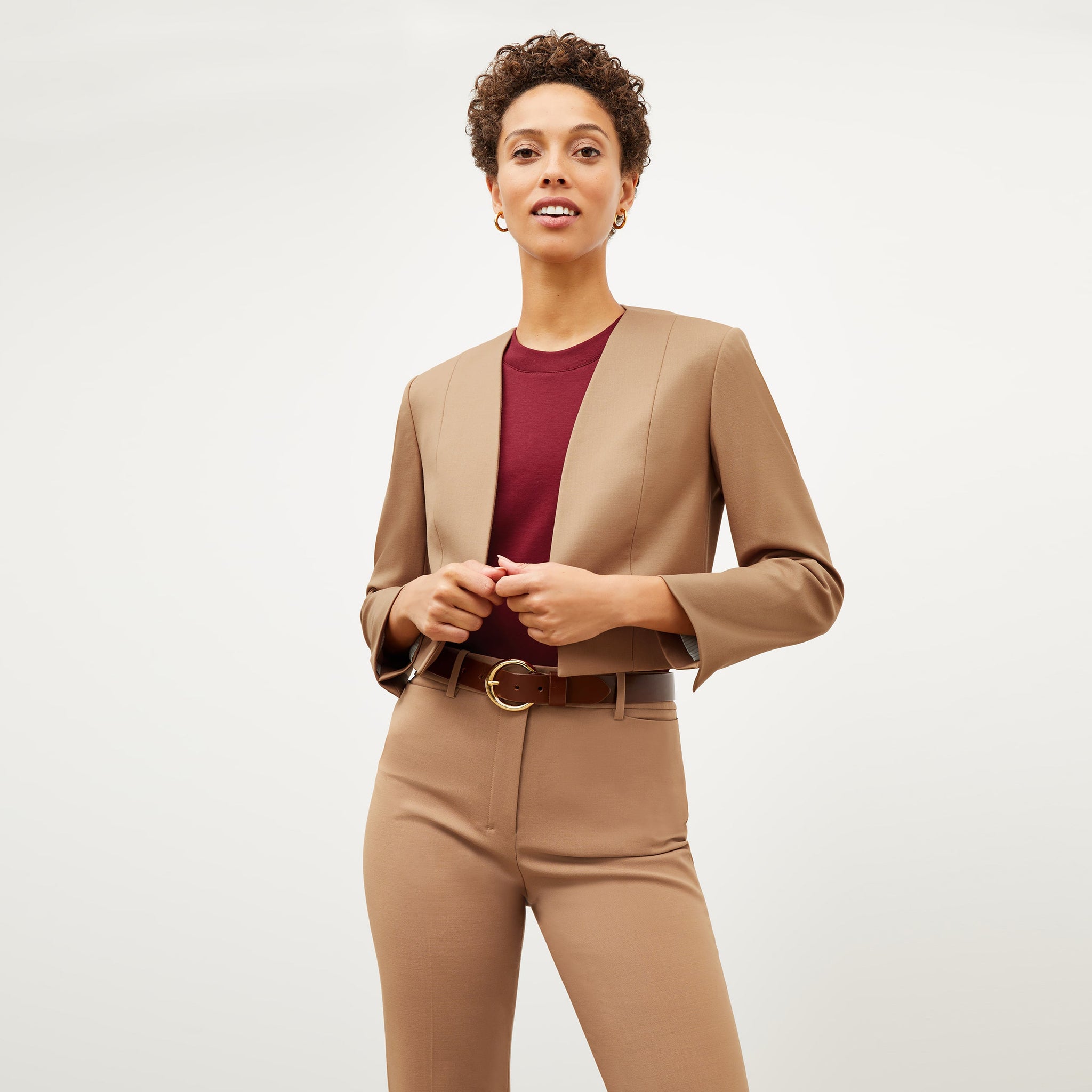 Front image of a woman standing wearing the Neale jacket in camel
