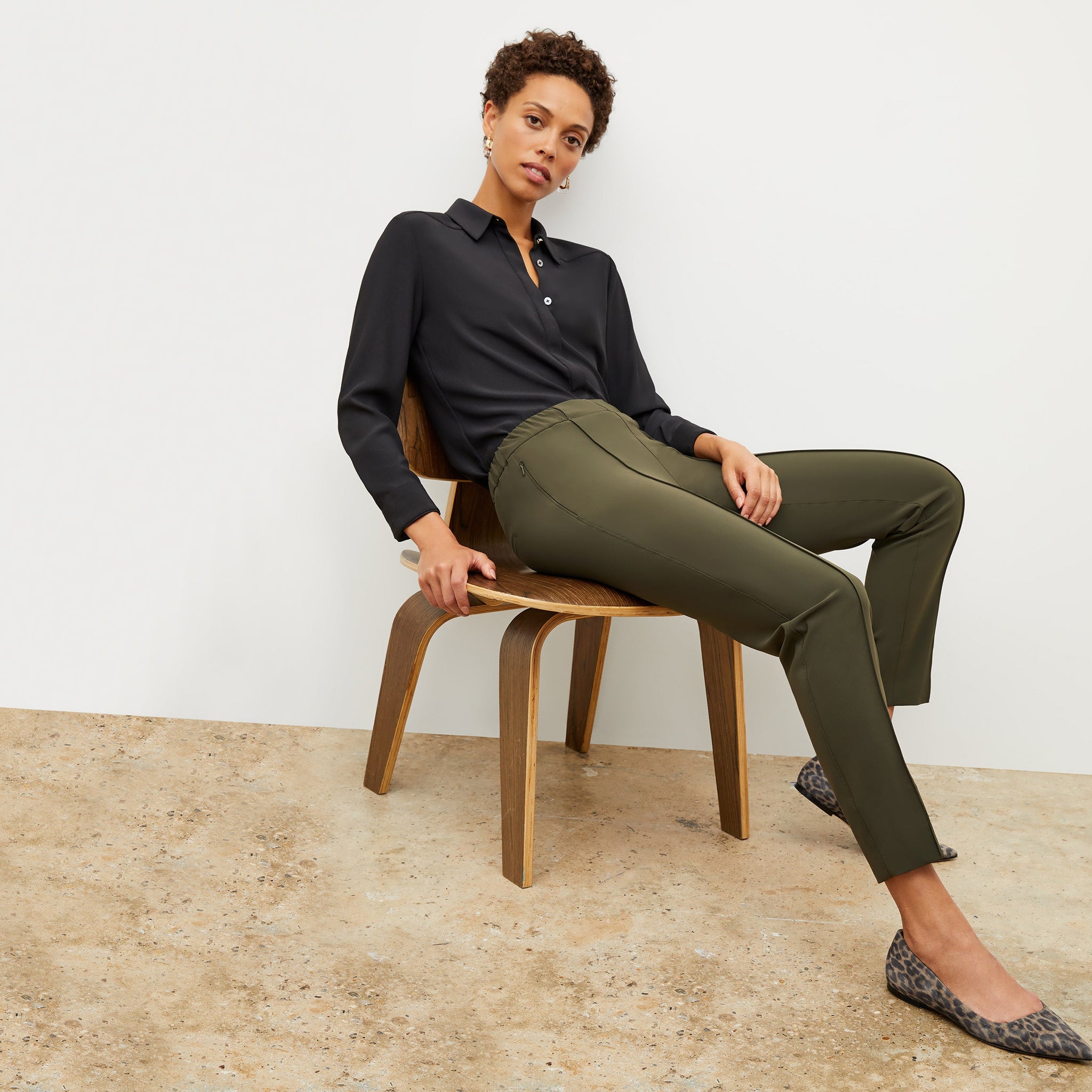 Front image of a woman standing wearing the colby pant in olive