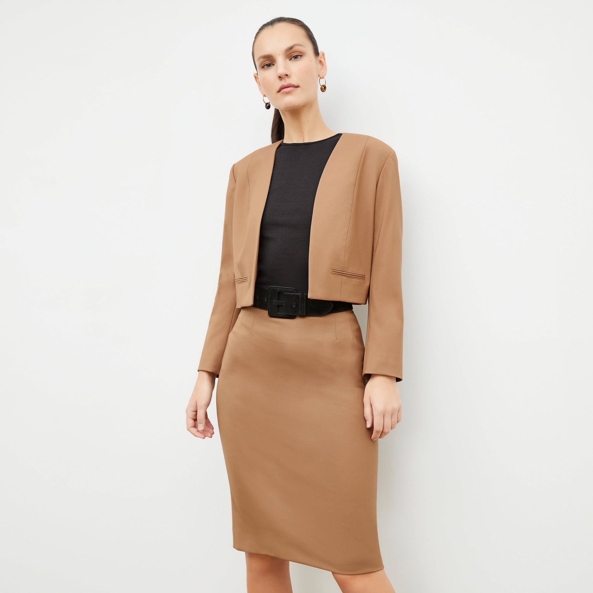 Front image of a woman standing wearing the Neale jacket in camel