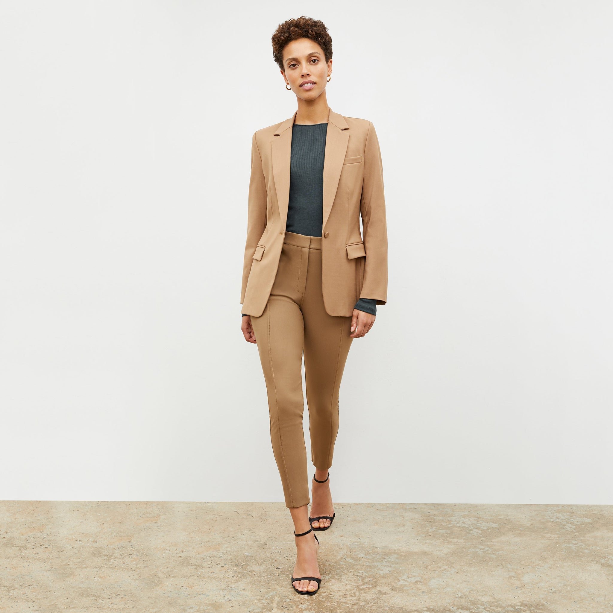 Front image of a woman standing wearing the Yiyan Blazer in Camel