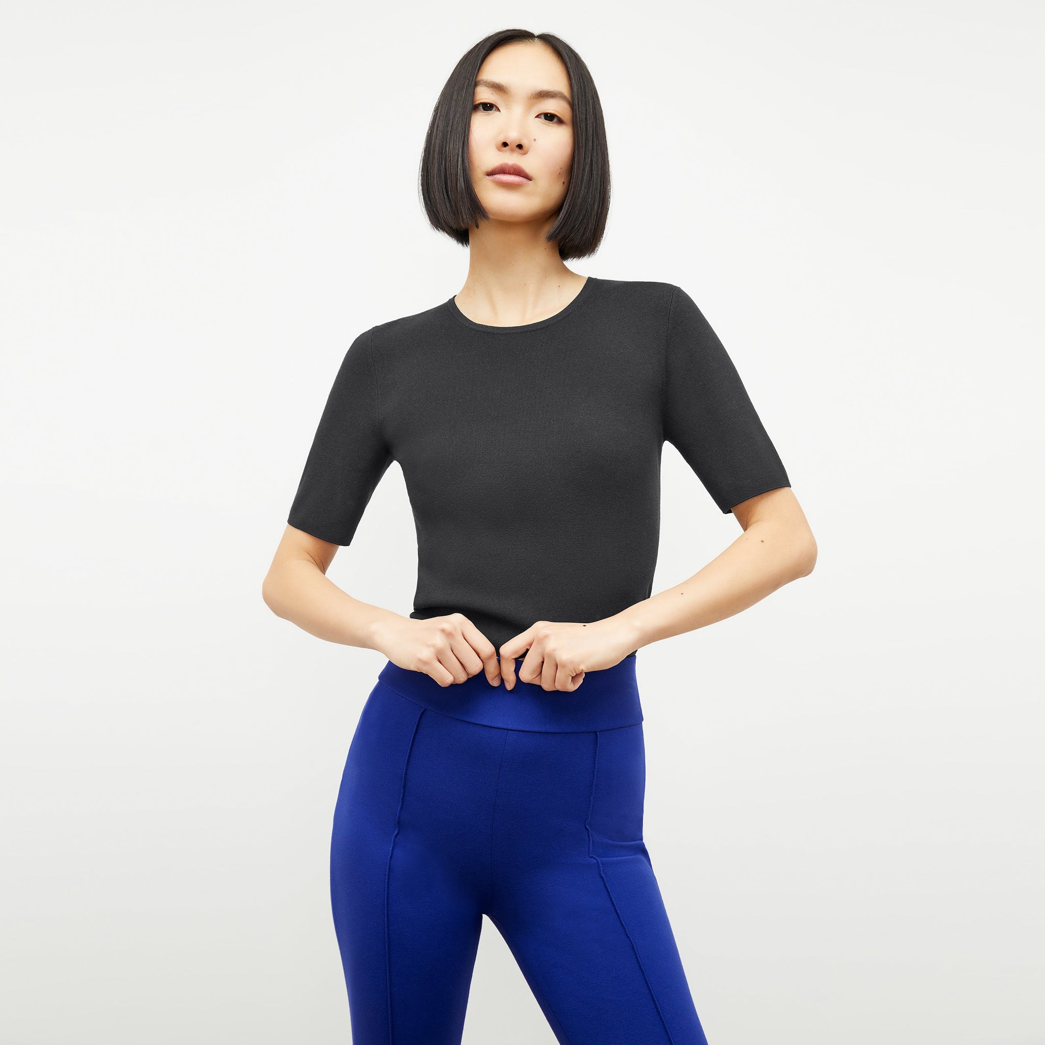 Front image of a woman wearing the choe top in black