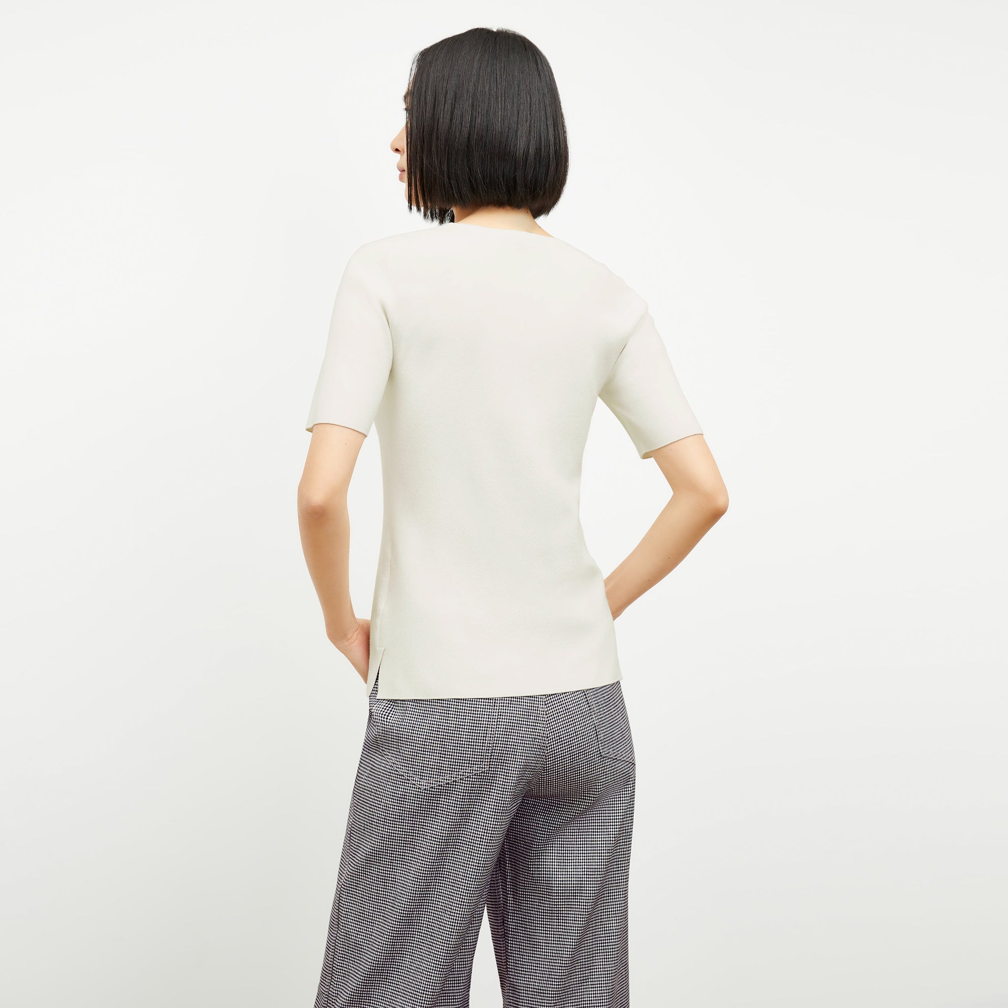 Front image of a woman standing wearing the choe top in ivory