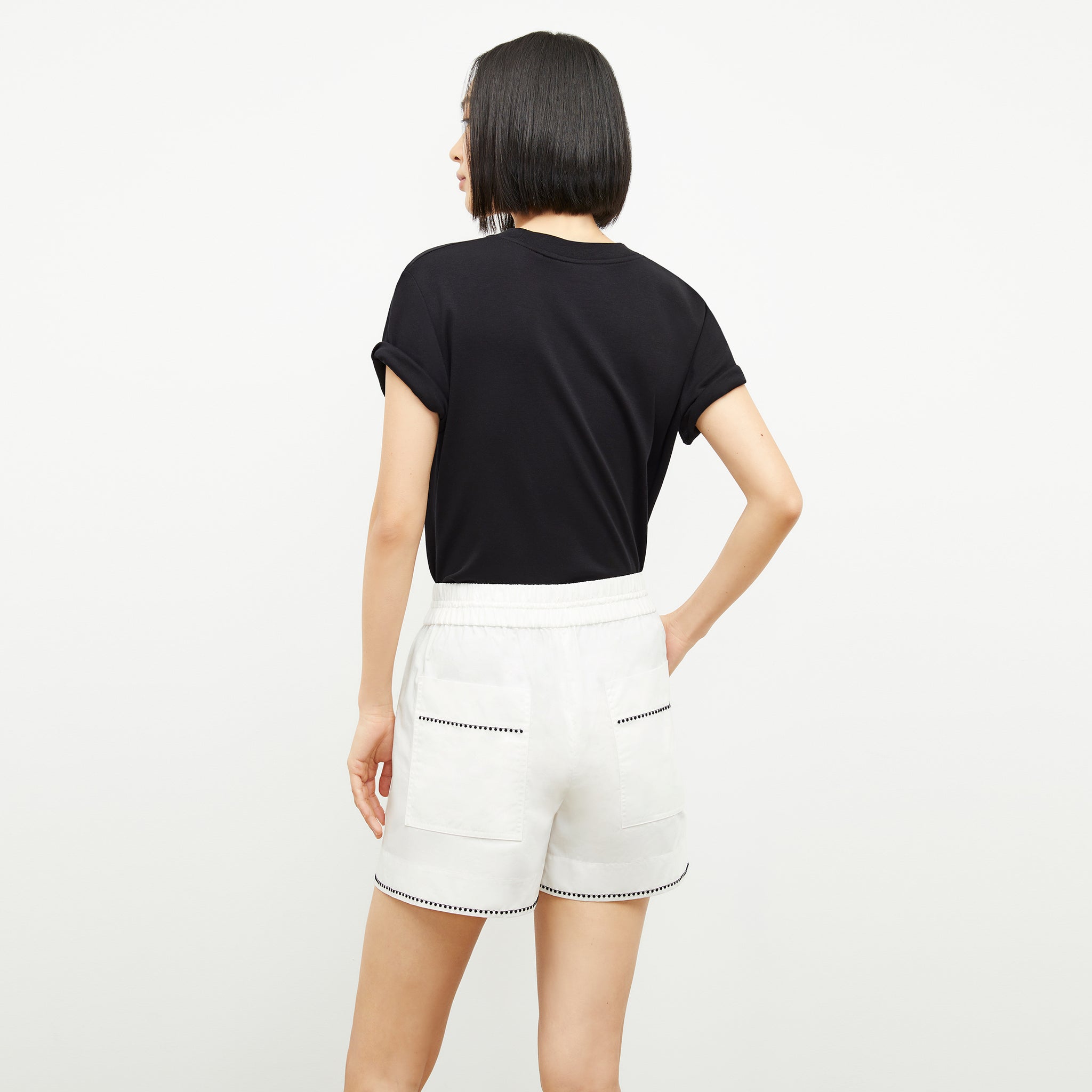 back image of a woman wearing the adina short in white
