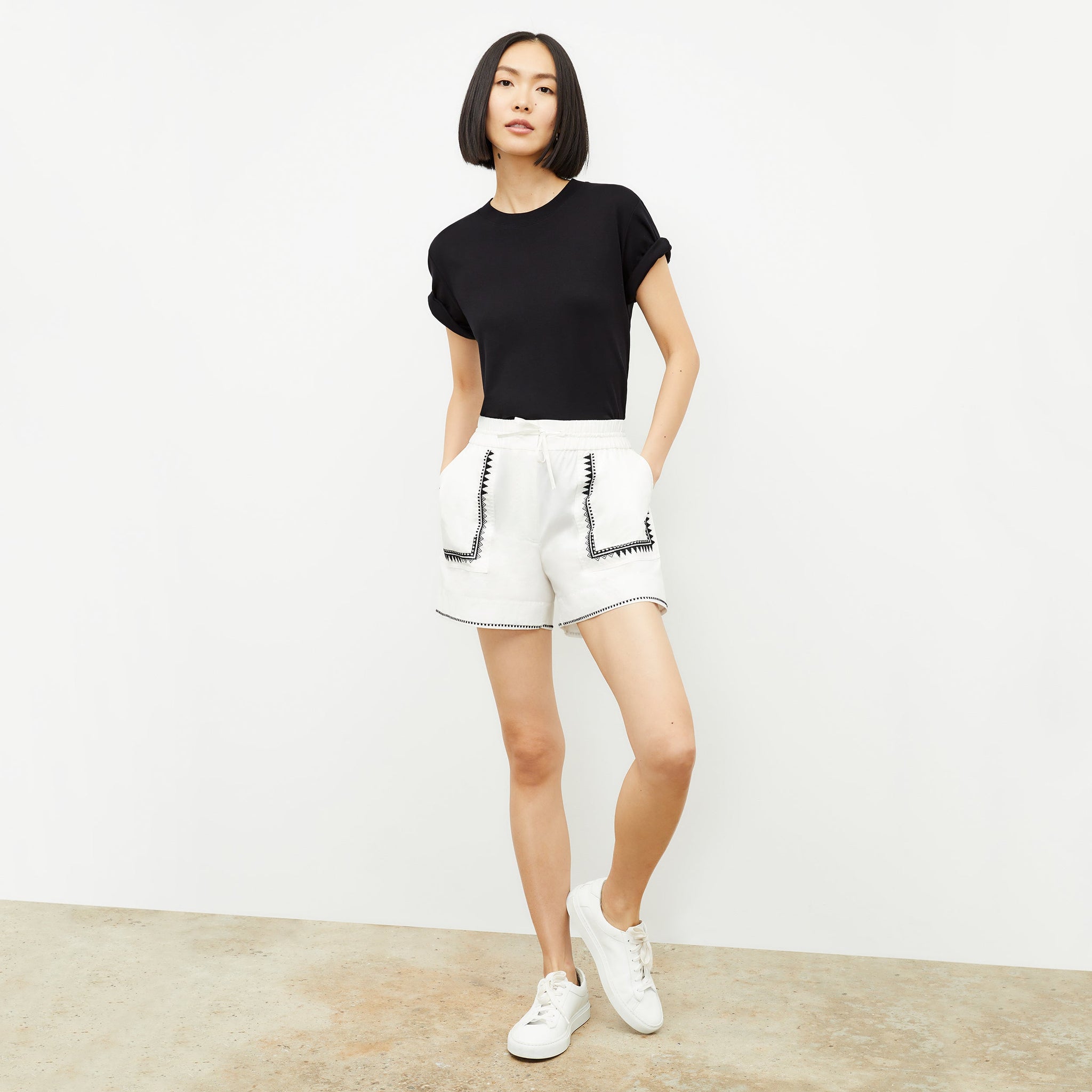 Front image of a woman standing wearing the leslie top in compact cotton in black