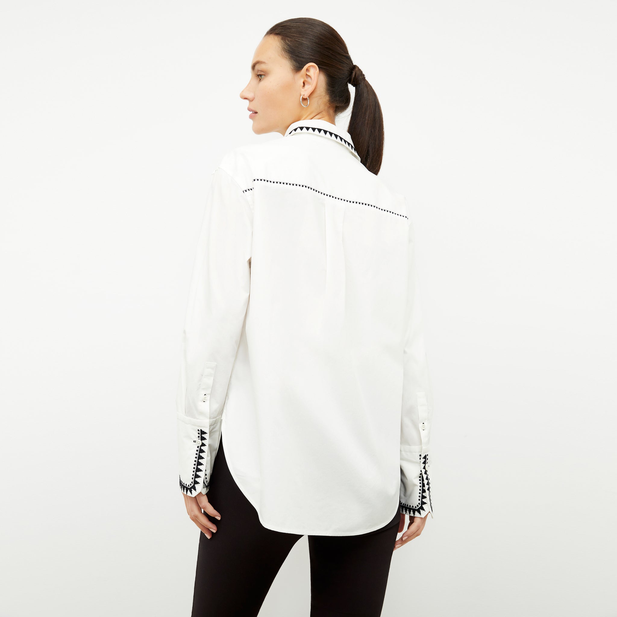 back image of a woman wearing the mila button down in white