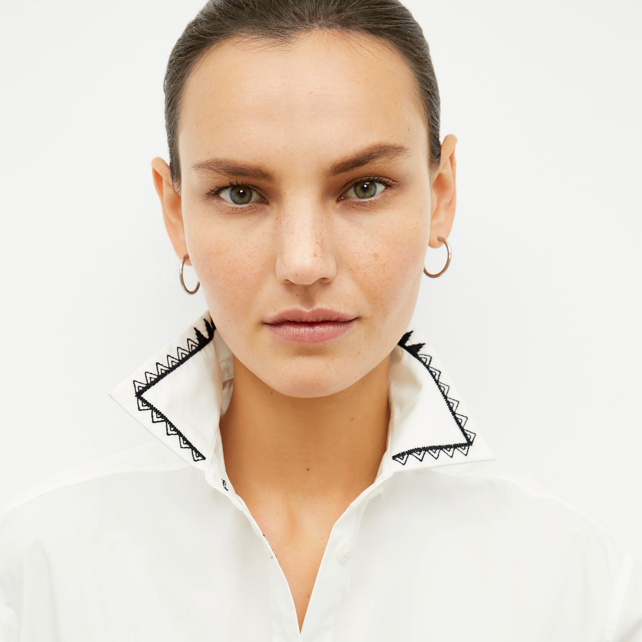 front image of a woman wearing the mila button down in white
