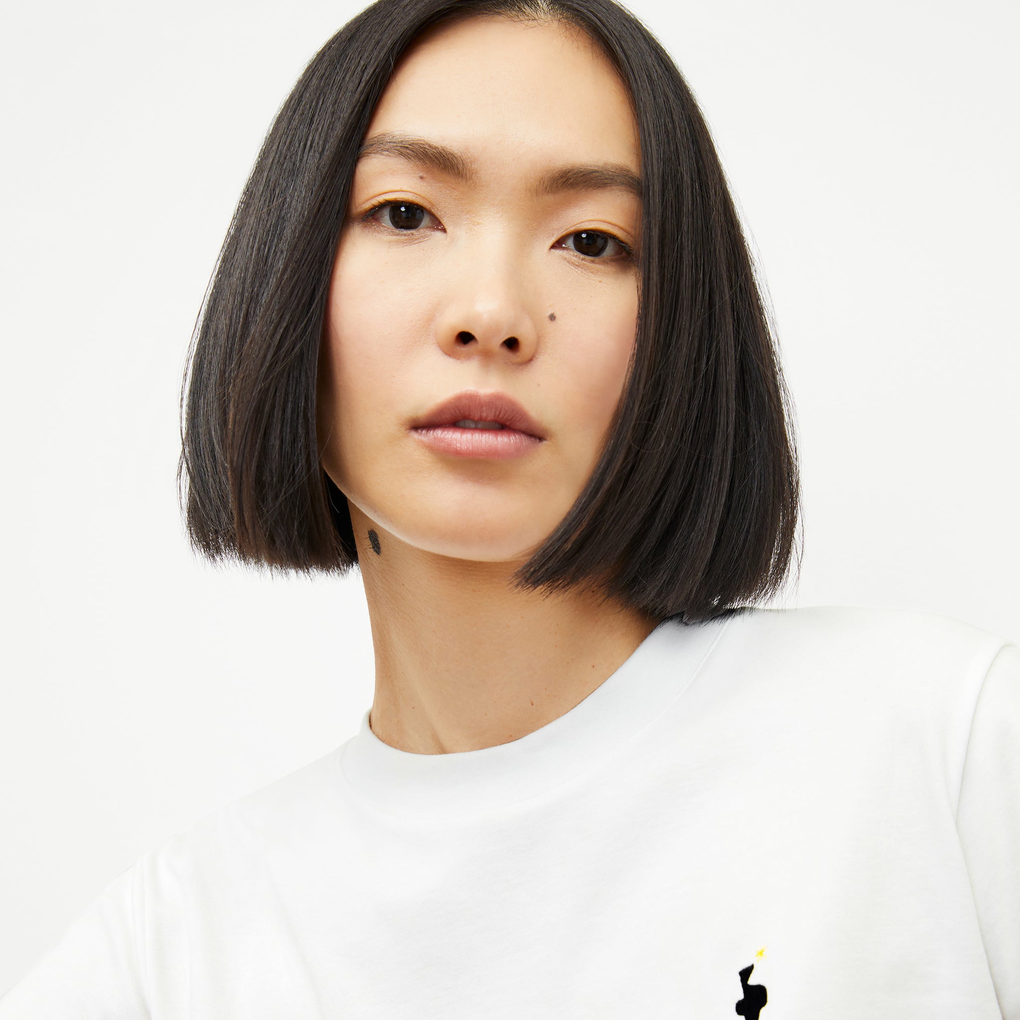 front image of a woman wearing the leslie t-shirt embroidered in white