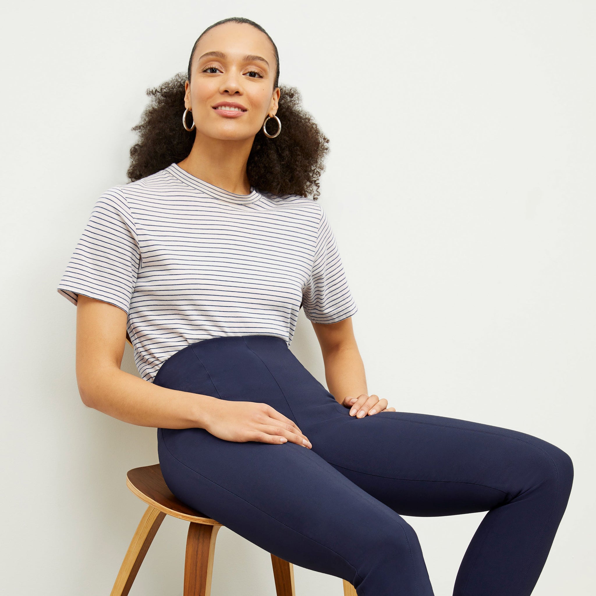 Front image of a woman standing wearing the foster pant in dark navy