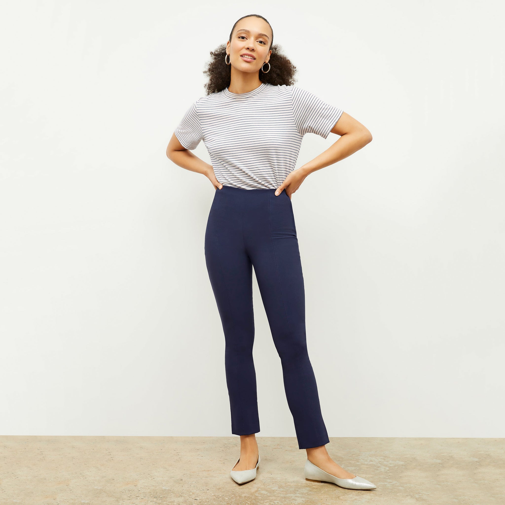 Front image of a woman standing wearing the foster pant in dark navy