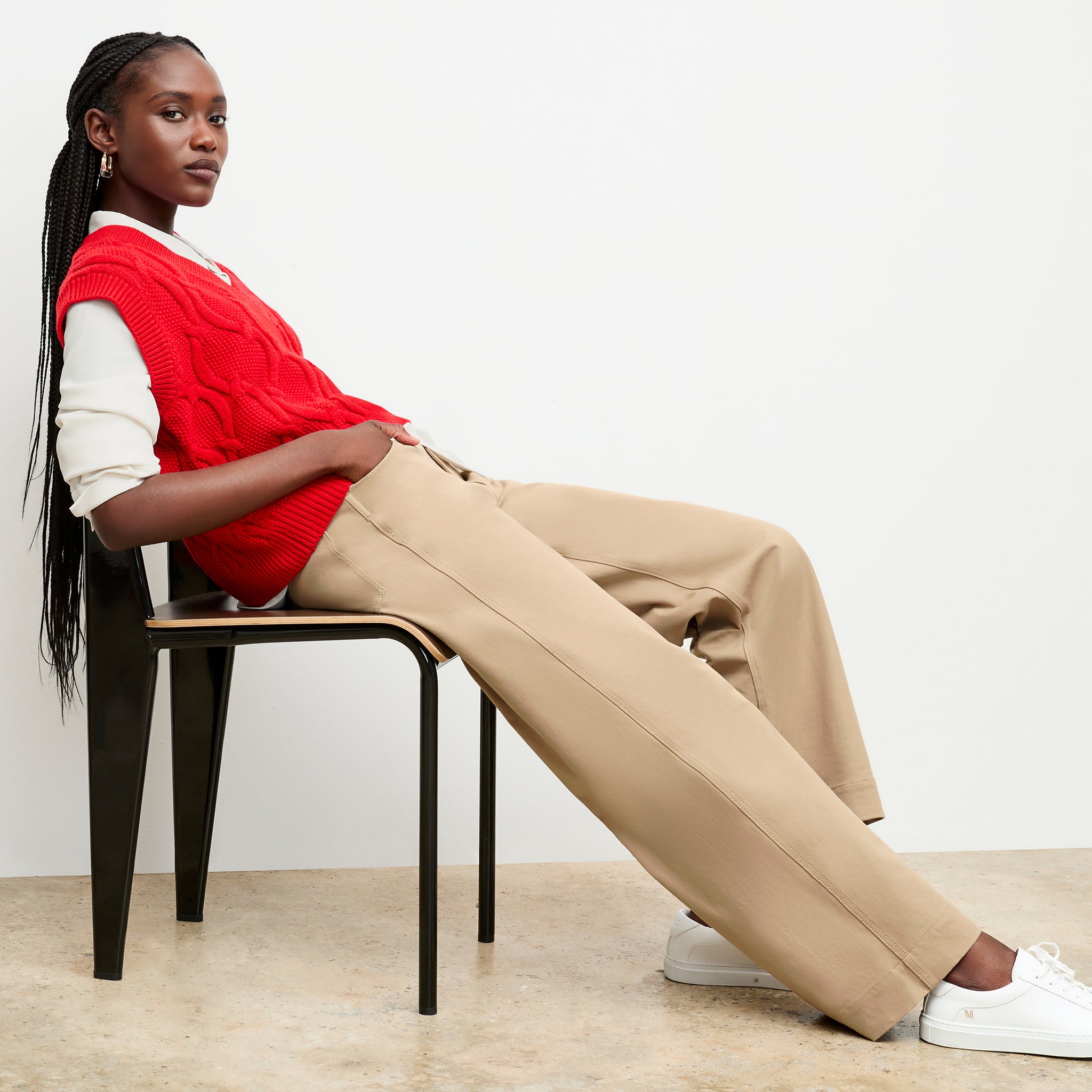 Front image of a woman sitting wearing the Milo jean in Beige