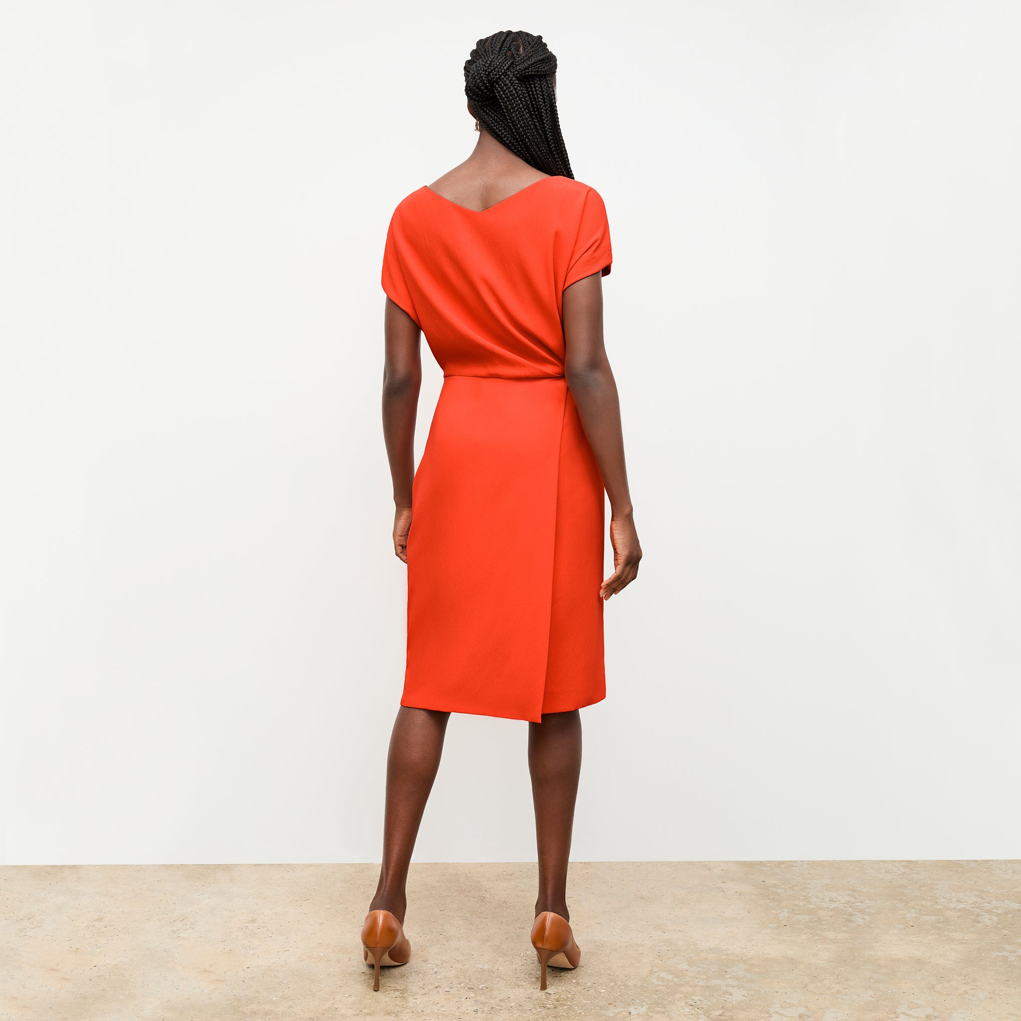 back image of a woman wearing the jillian dress in bright coral