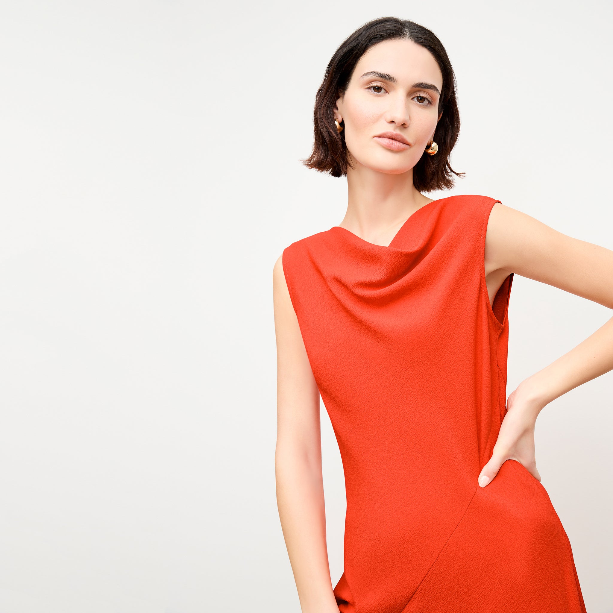 front image of a woman wearing the priya dress in bright coral 
