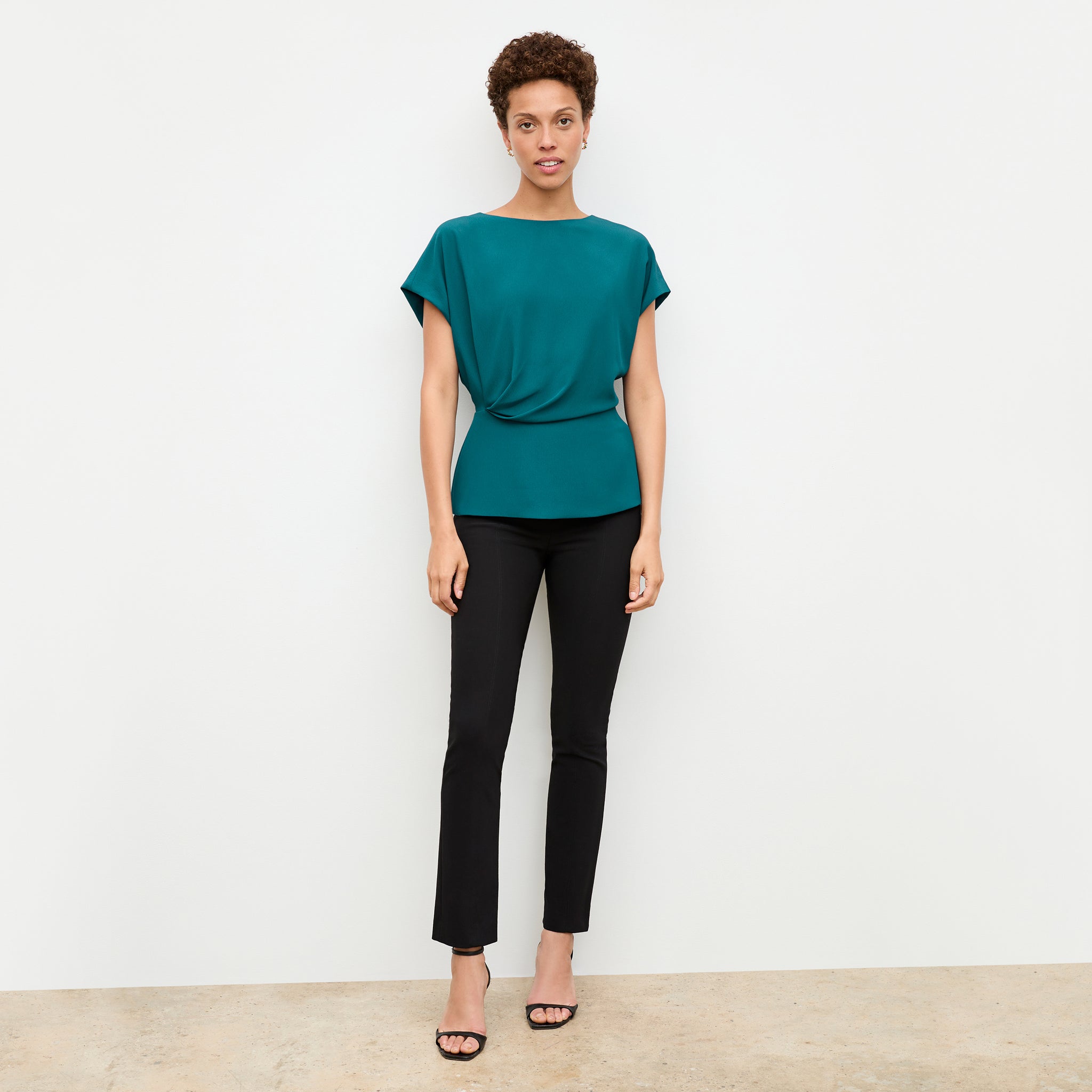 front image of a woman wearing the nejvi top in mineral blue 