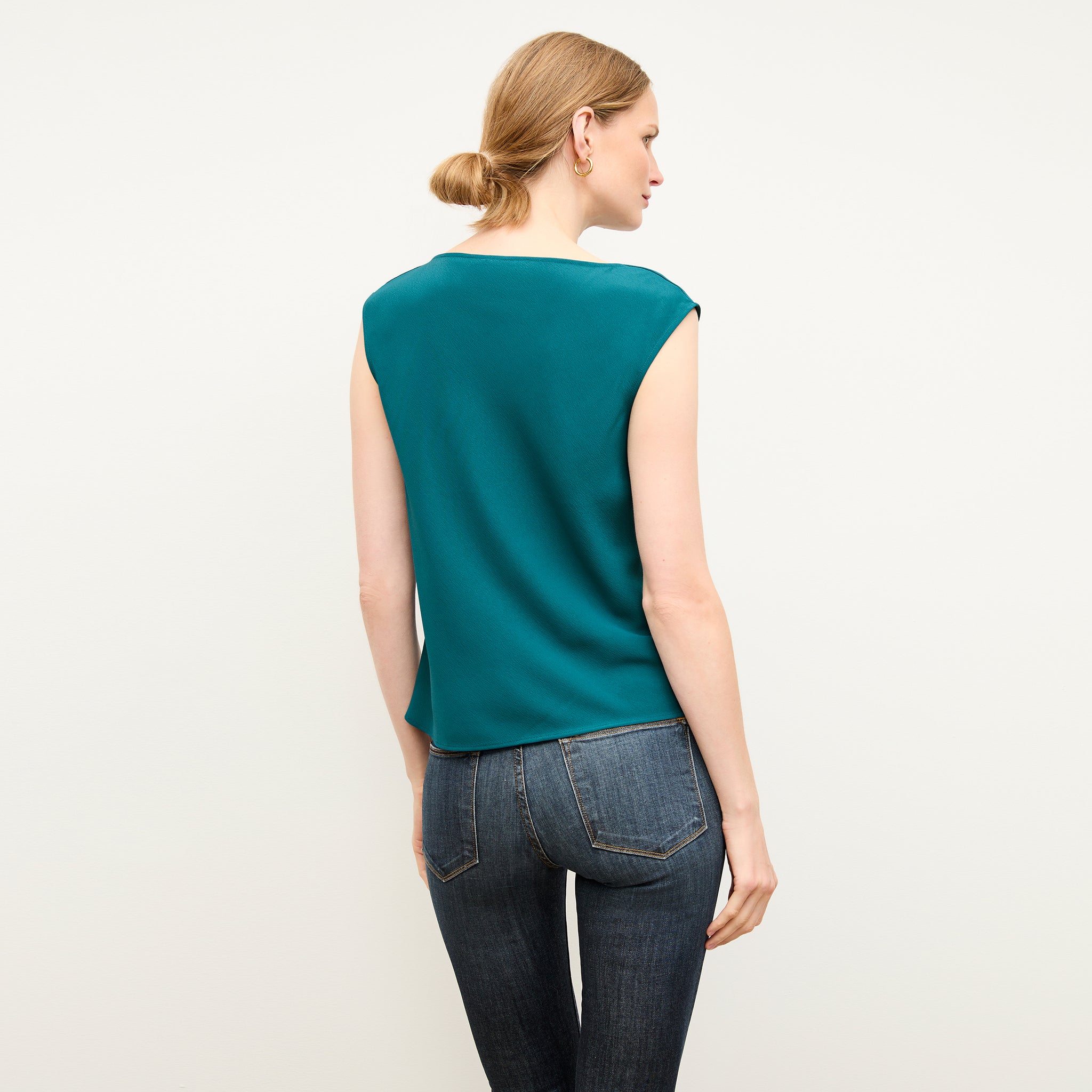 back image of a woman wearing the nora top in mineral blue