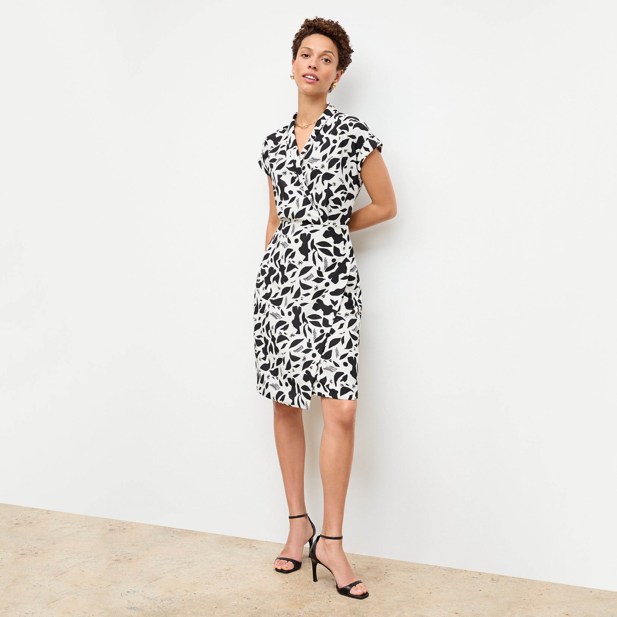 front image of a woman wearing the tory dress in icon print 