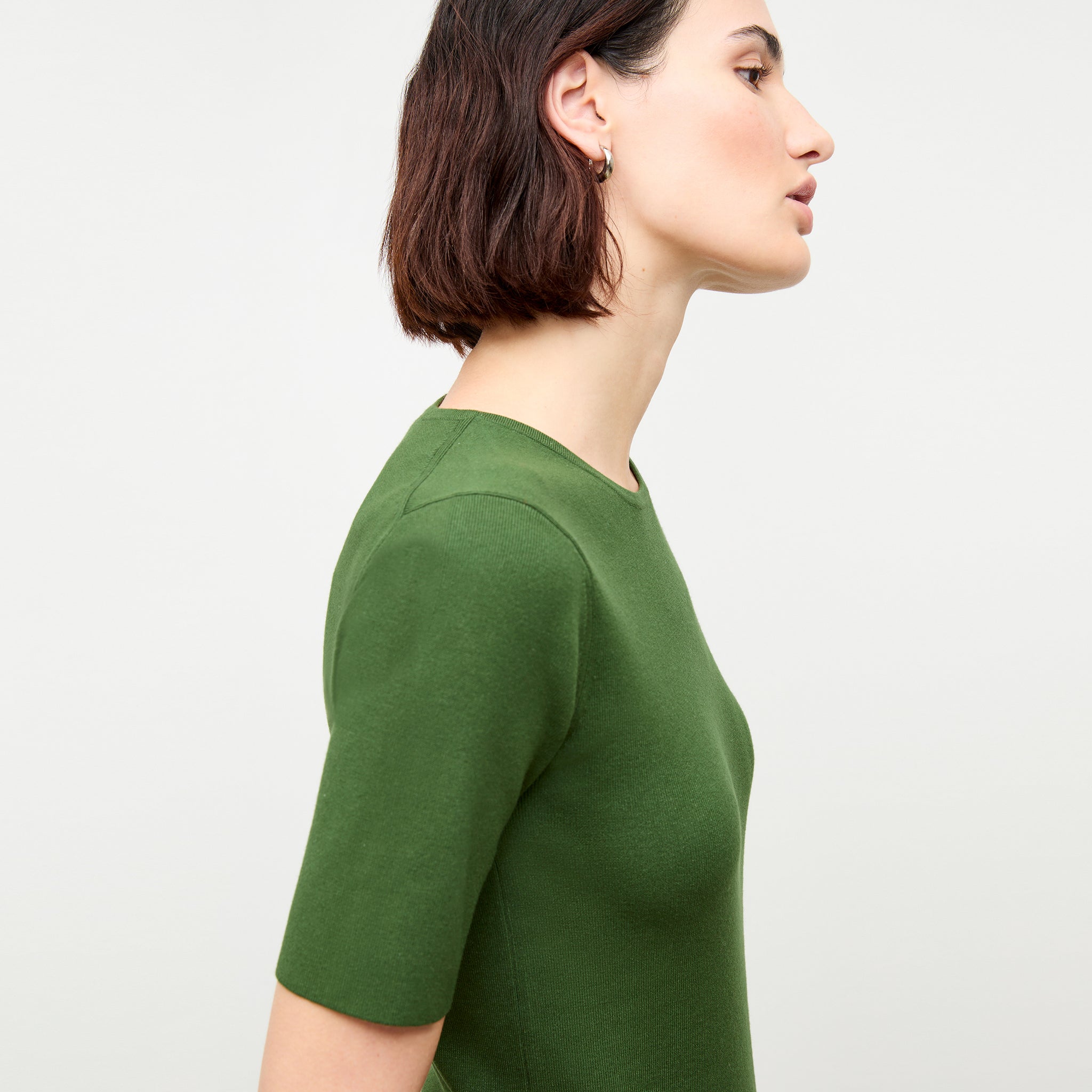 side image of a woman wearing the choe top in basil