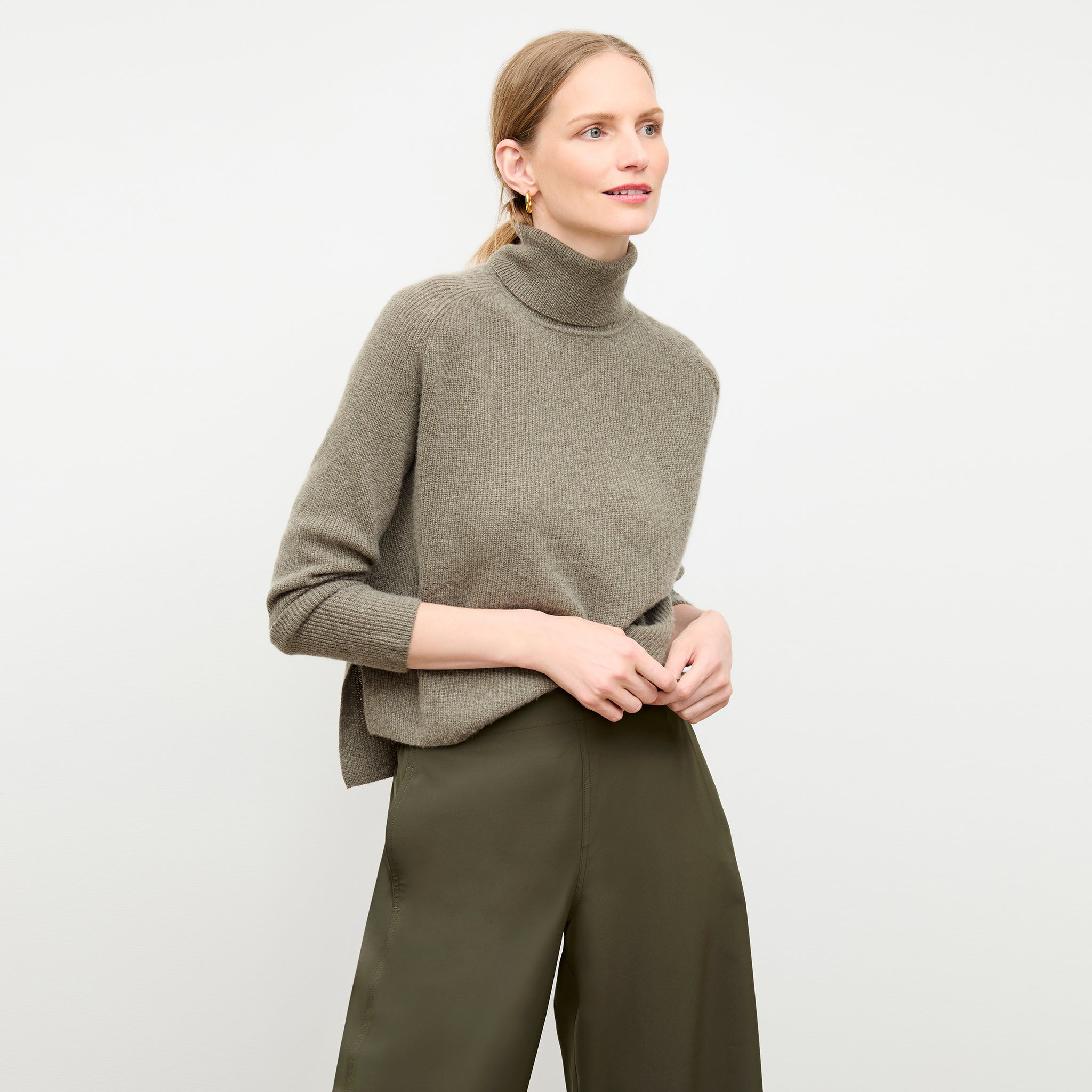 Front image of a woman wearing the arbus sweater in dark moss