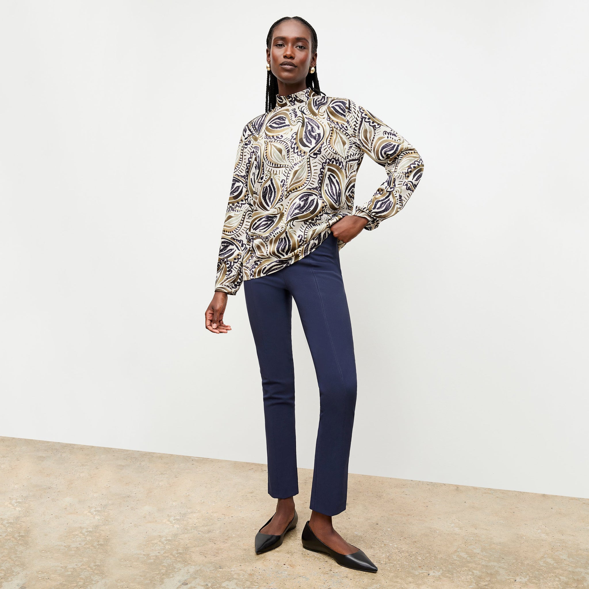 Front image of a woman standing wearing the foster pant in dark navy