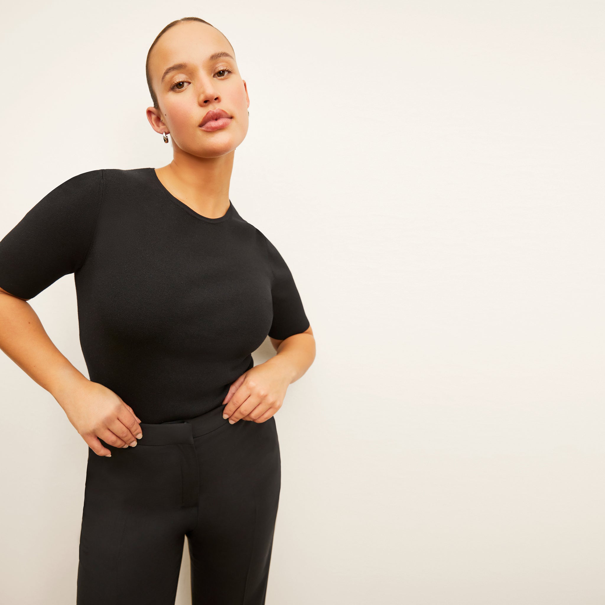 Front image of a woman standing wearing the Choe Top in Black