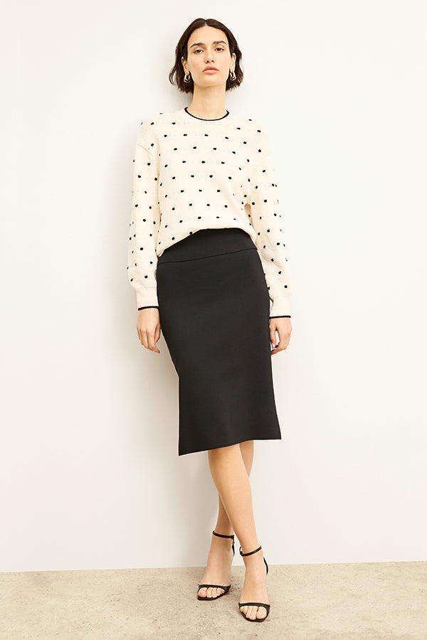 Front image of a woman standing wearing the harlem skirt in black
