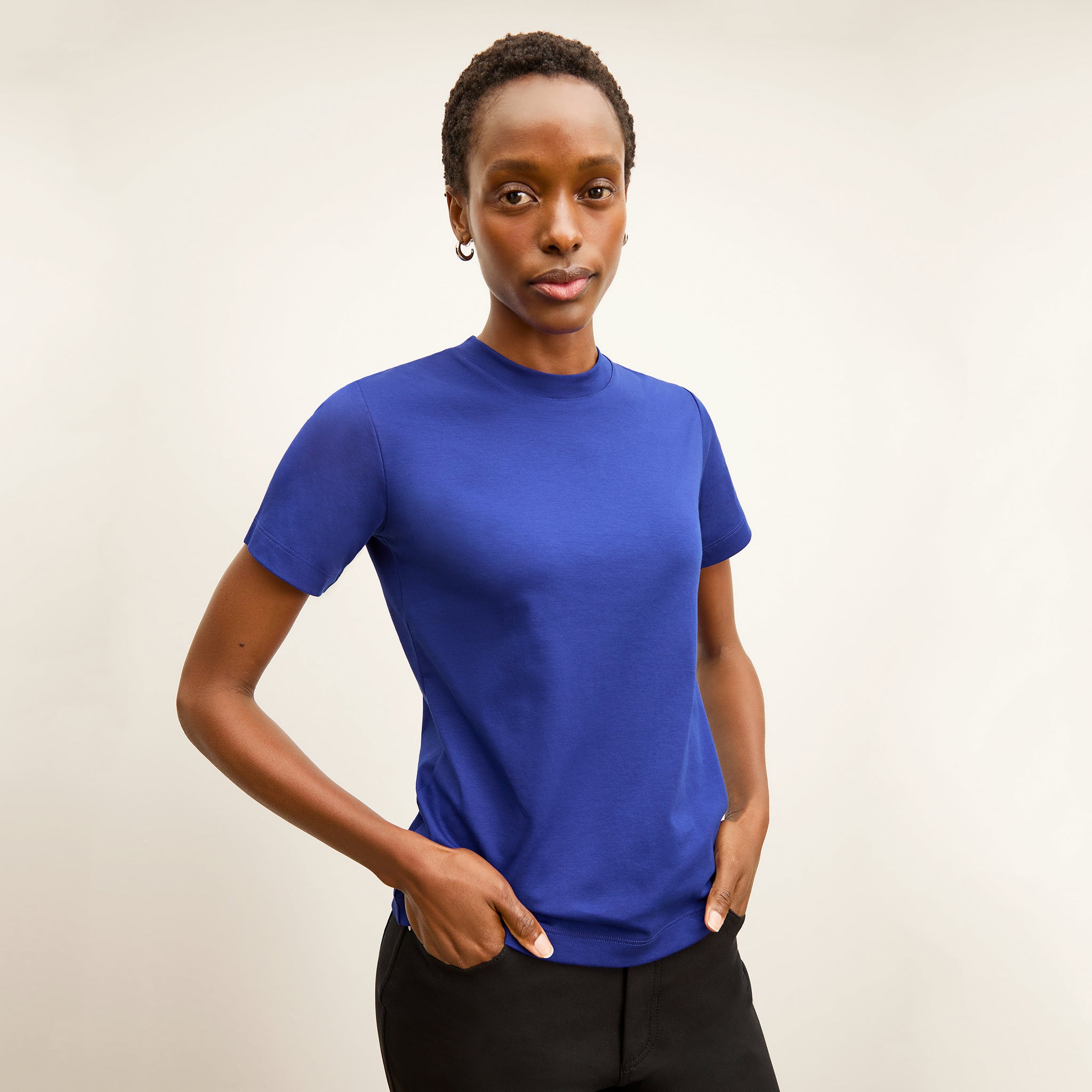 front image of a woman wearing the leslie t-shirt in bright indigo