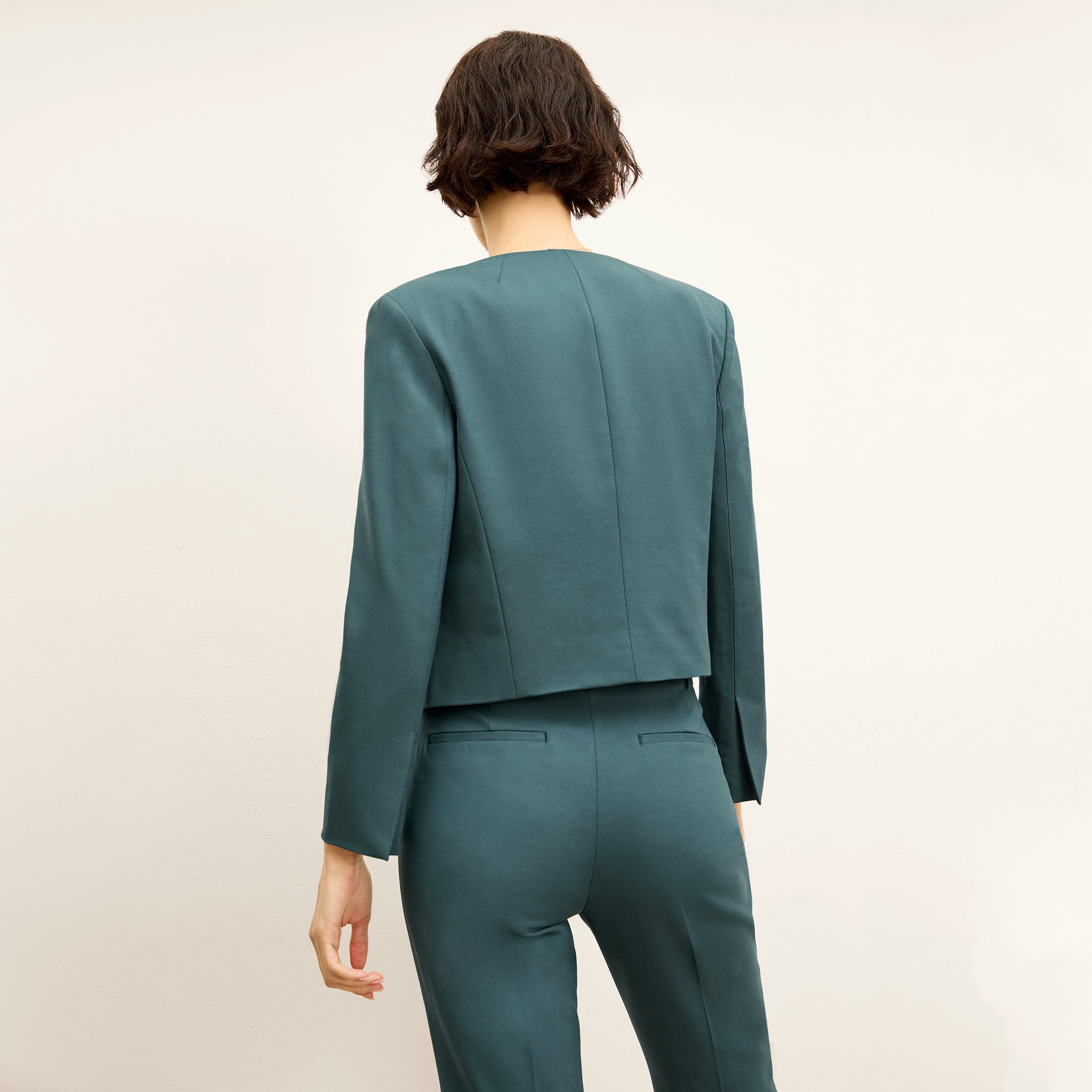 back image of a woman wearing the neale jacket in blue jade