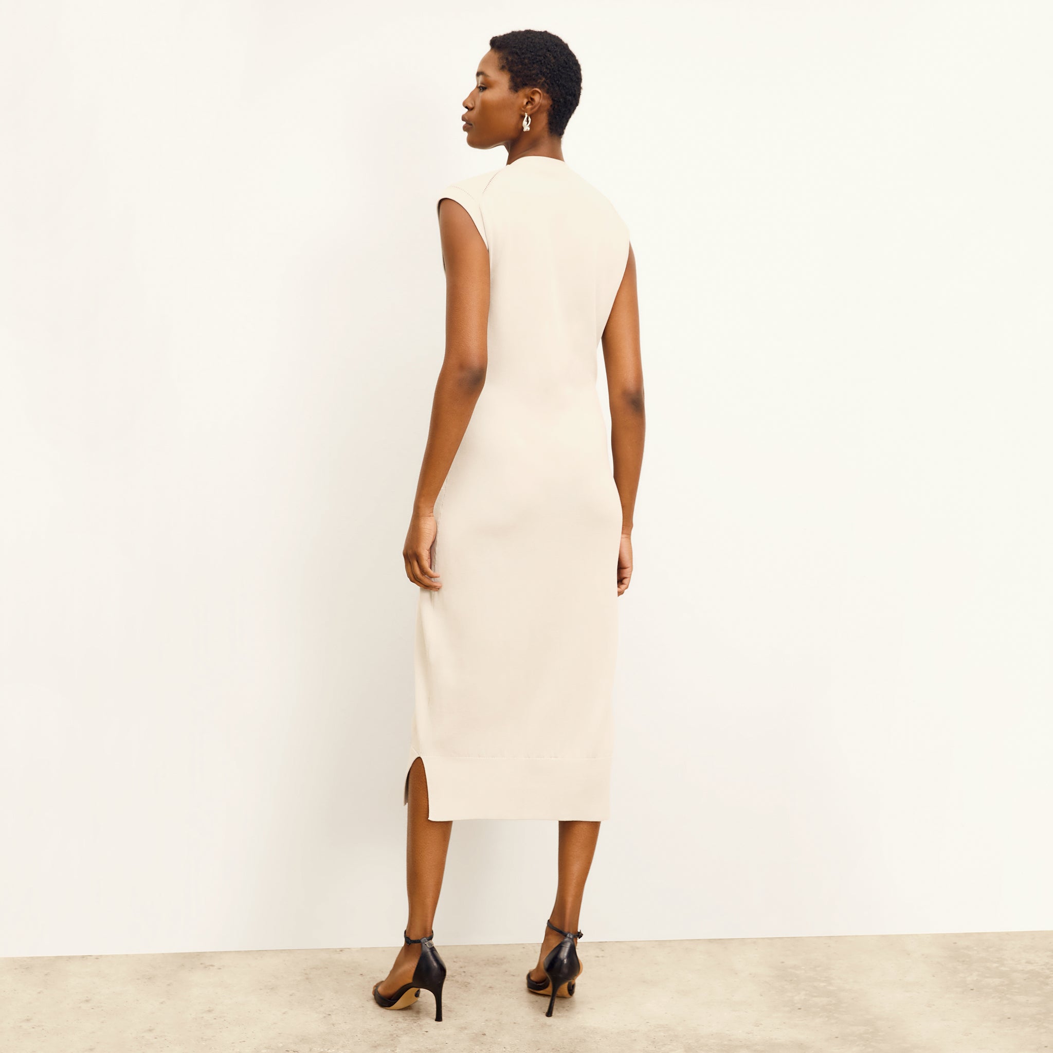 back image of a woman wearing the toula dress in ivory