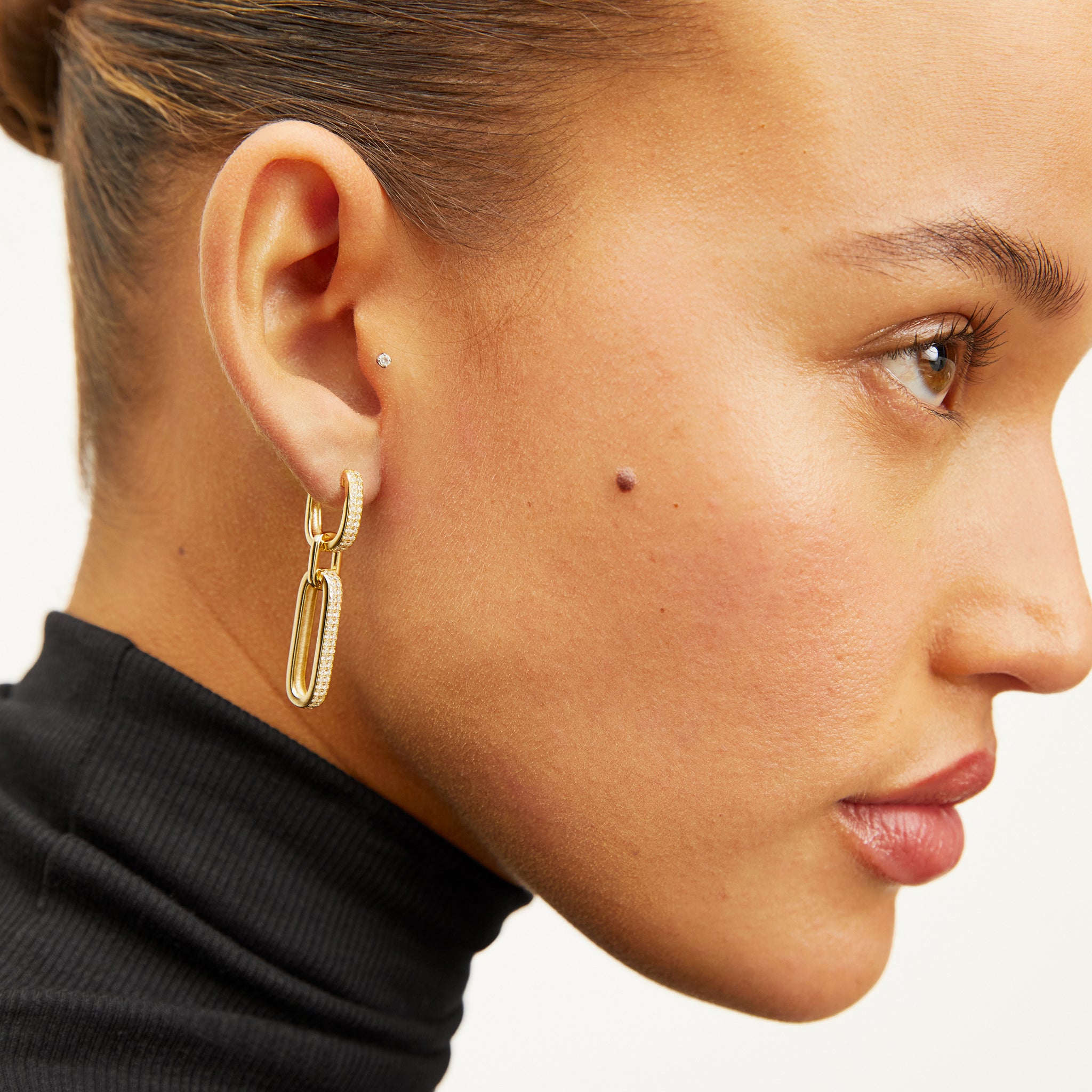 image of a woman wearing the flora earrings in gold