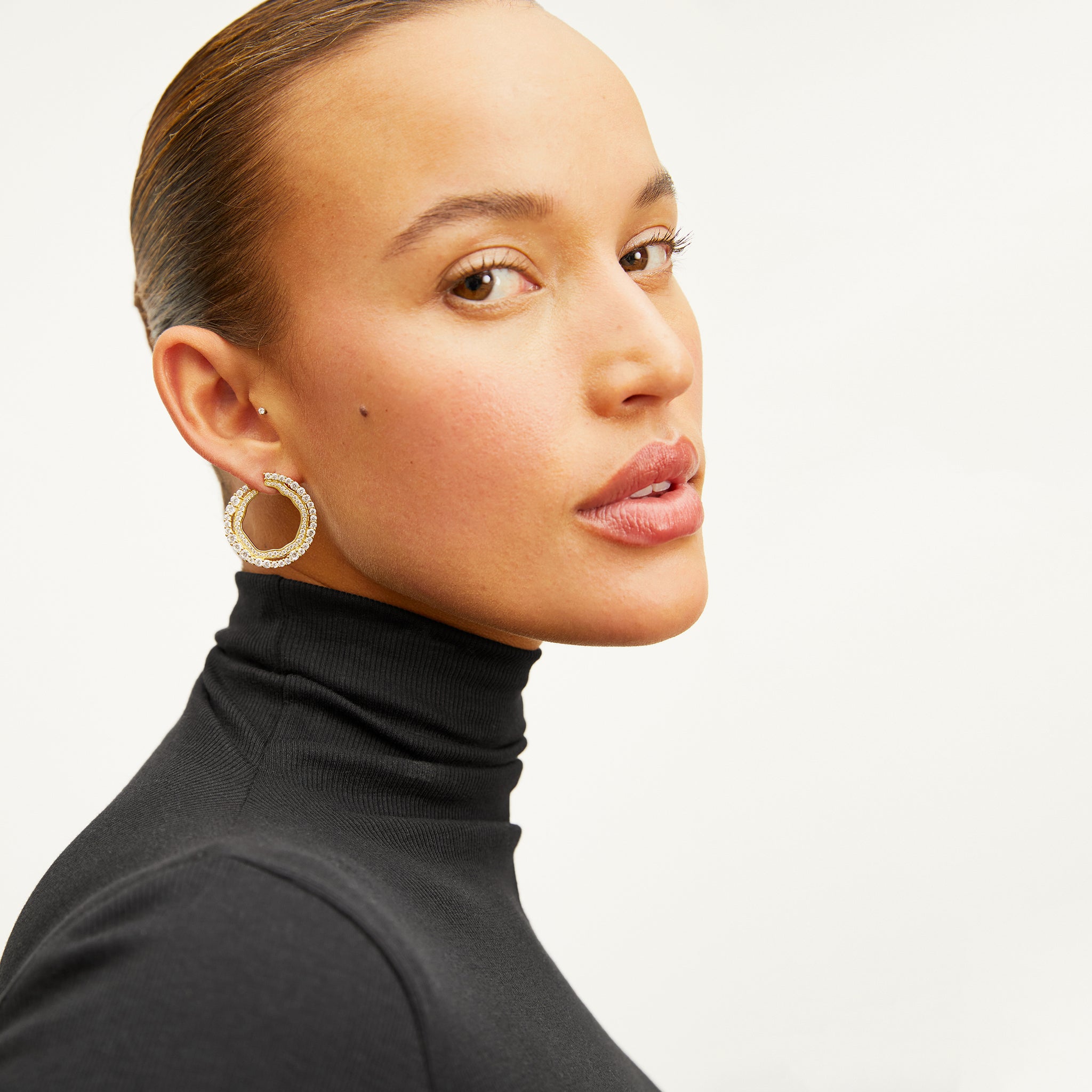 image of a woman wearing the yang earrings in gold 