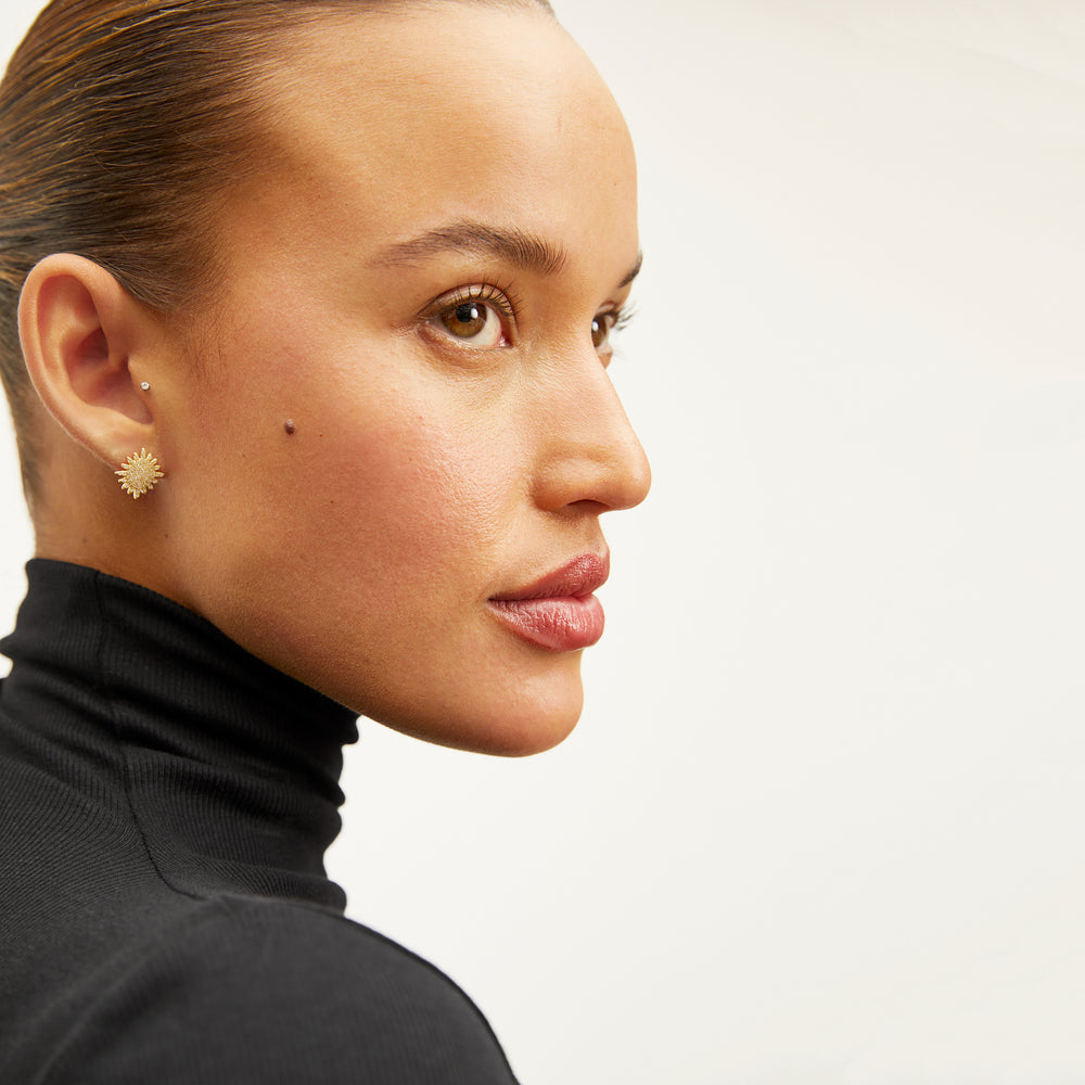 image of a woman wearing the indira earrings in gold