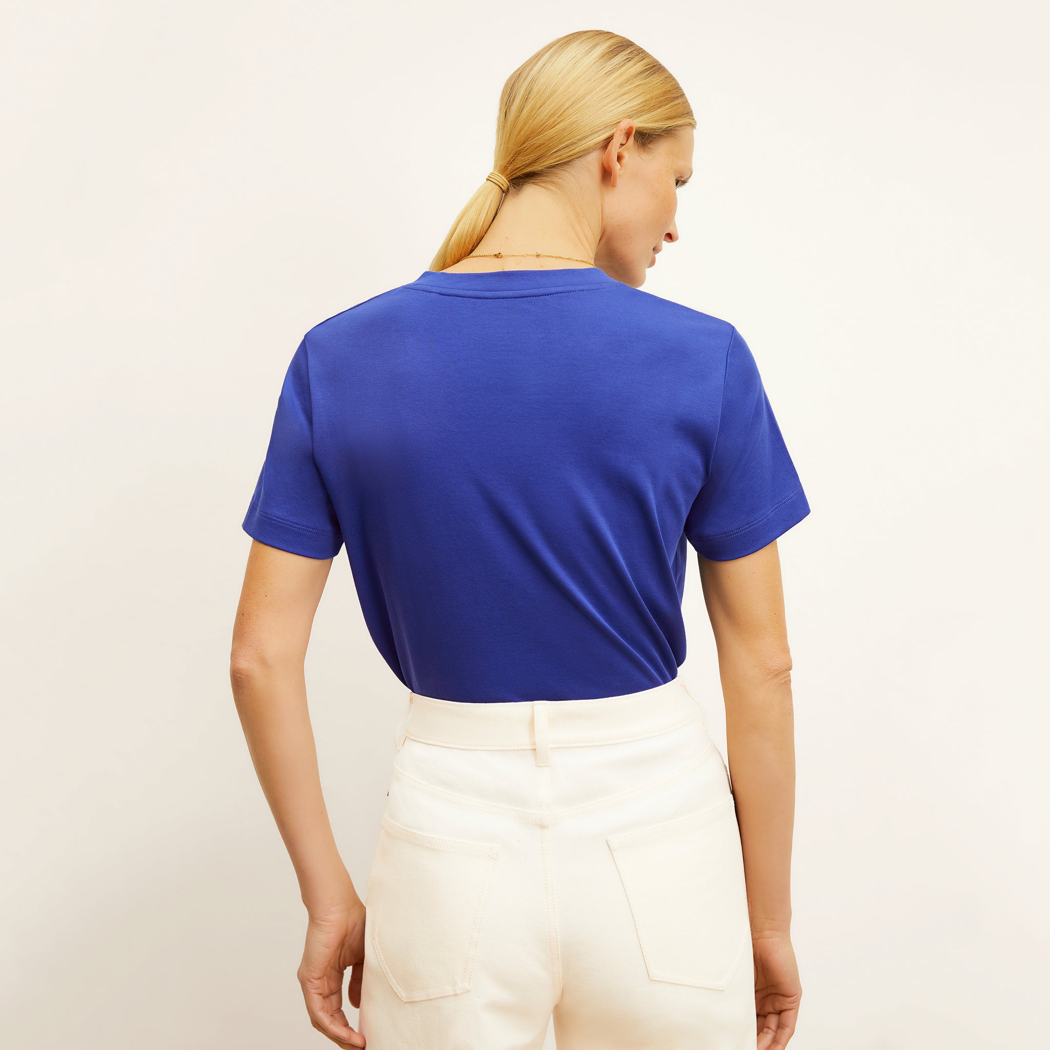 back image of a woman wearing the lee t-shirt in bright indigo