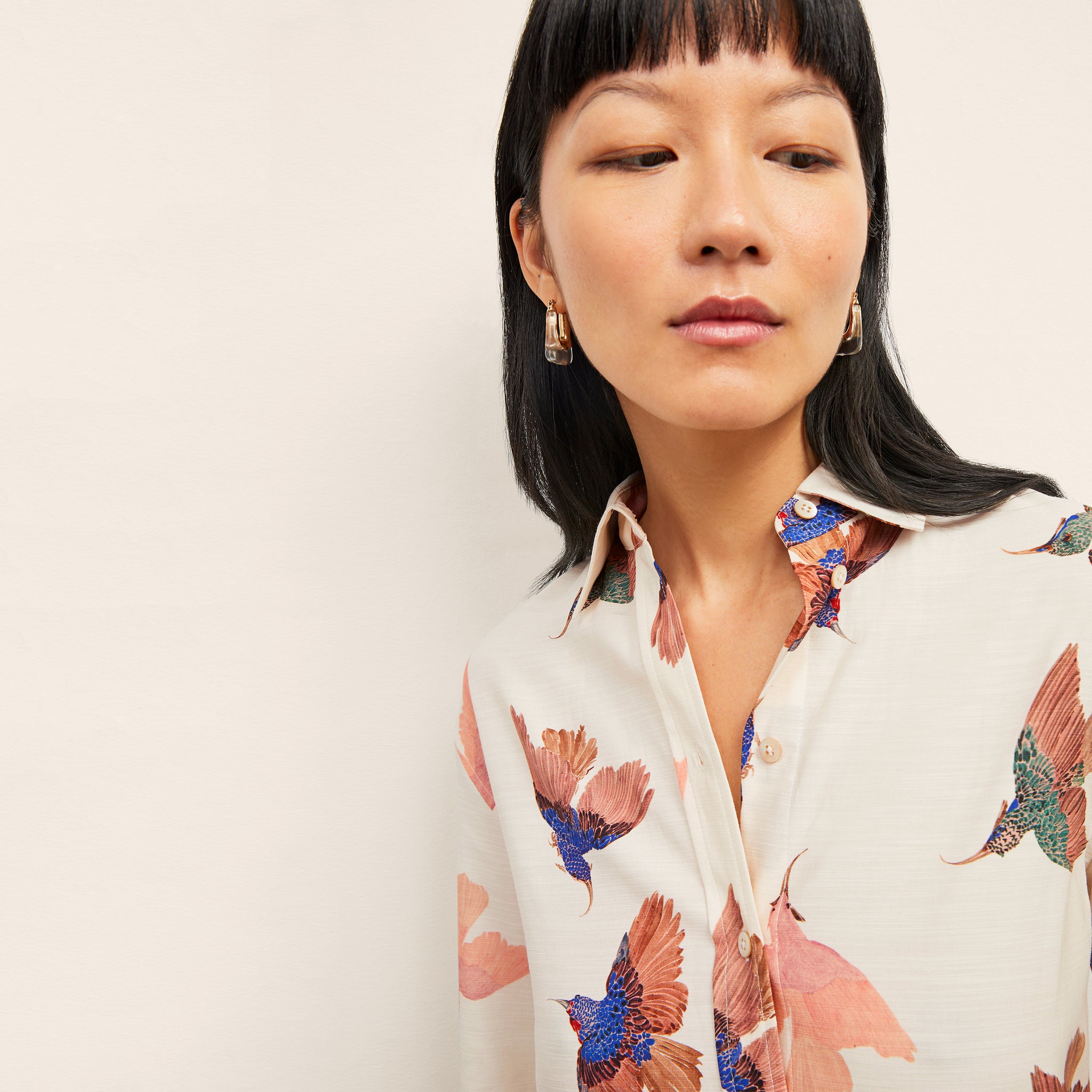 front image of a woman wearing the mila top in hummingbird print