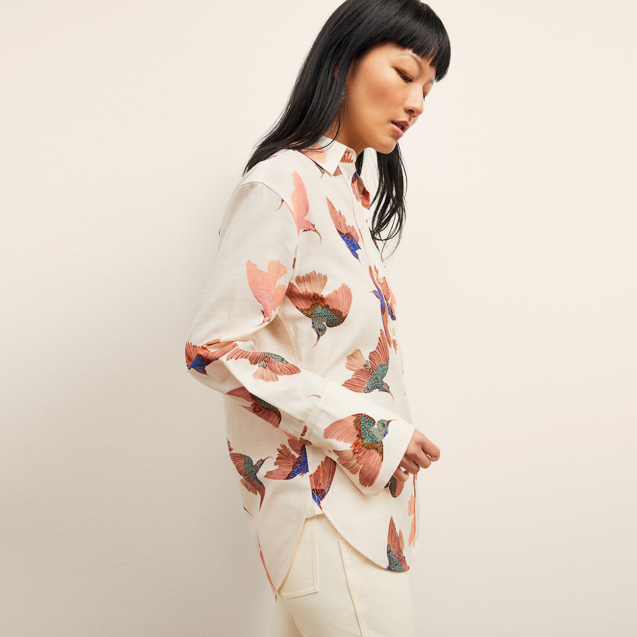 side image of a woman wearing the mila top in hummingbird print