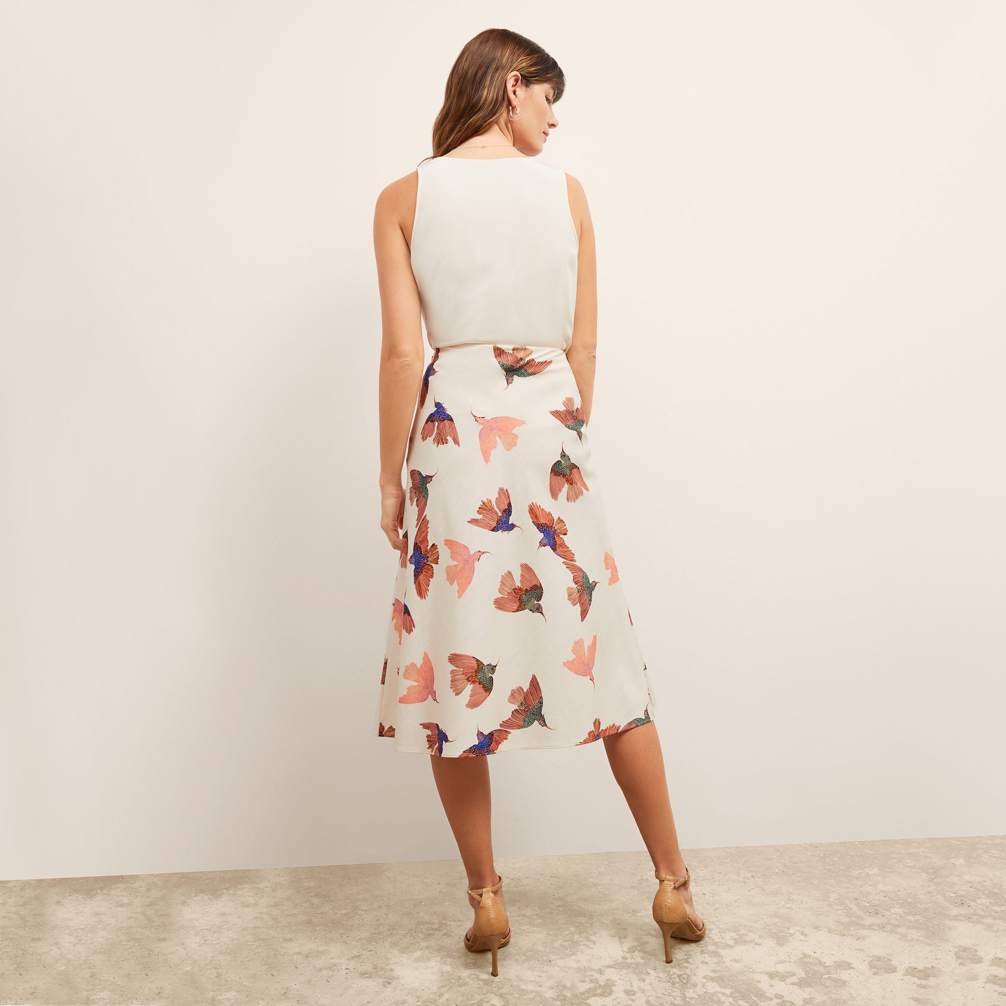 back image of a woman wearing the orchard skirt in hummingbird print