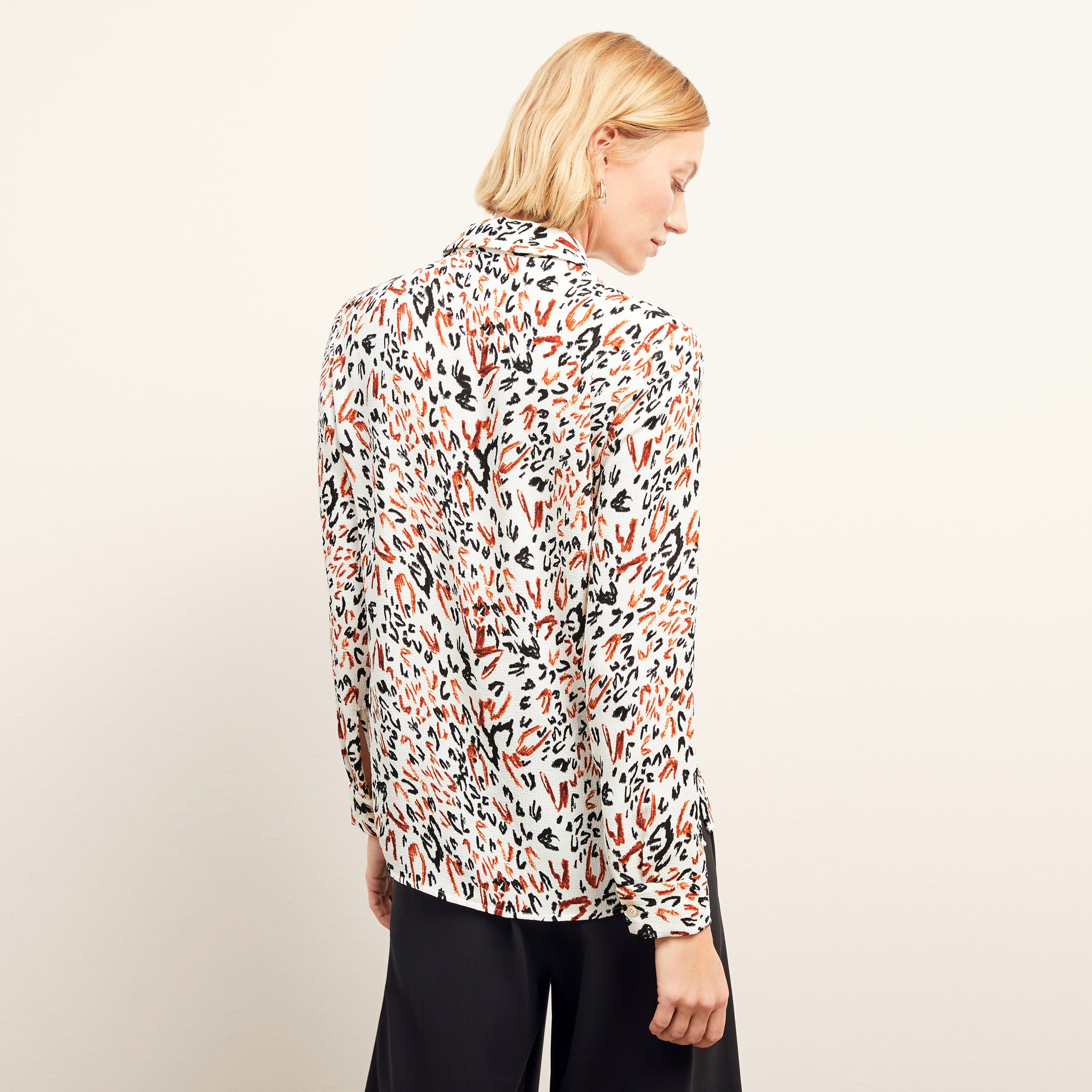 back image of a woman wearing the lagarde top in leopard sketch