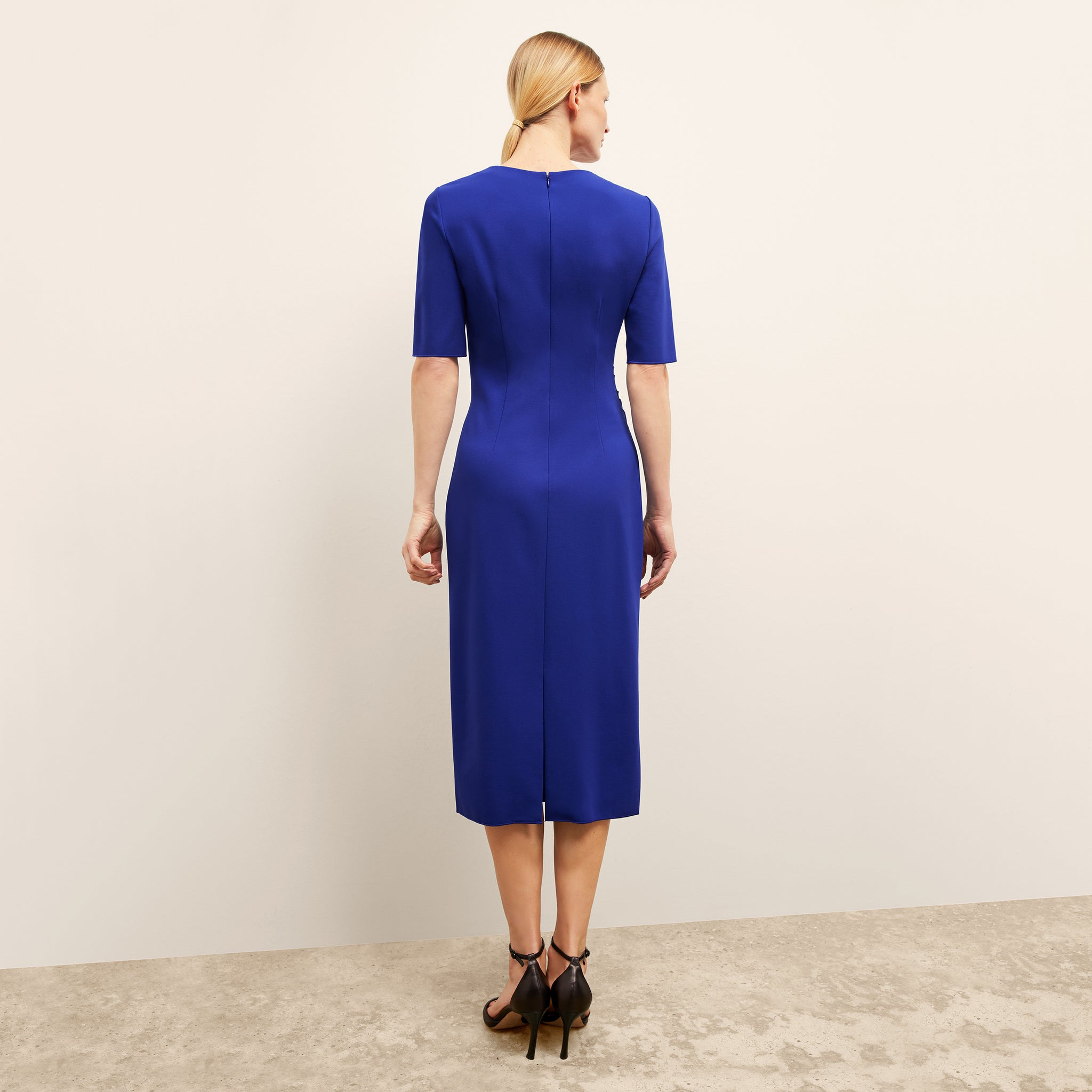 back image of a woman wearing the ciela dress in electric blue