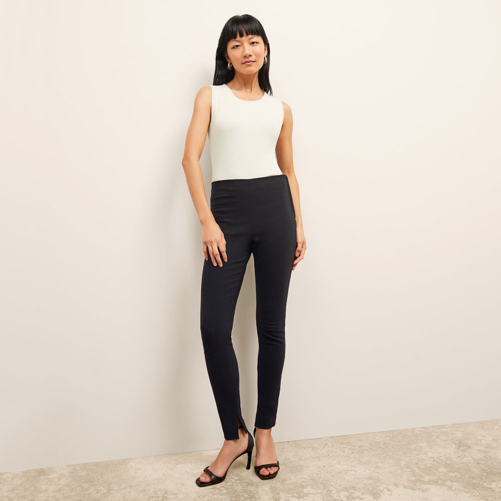 Front image of a woman standing wearing the paige top in fine ribbed cotton in ivory